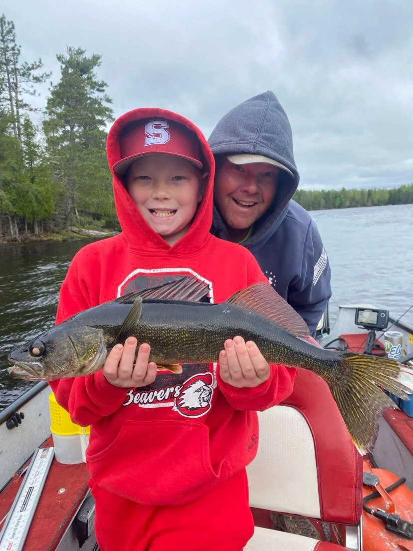 Father and son hold walleye caught on leech in boat Ely MN, BWCA area, June 11 2024. Arrowhead Outdoors Ely MN fishing report with premium tackle, hunting gear & camping supplies available.