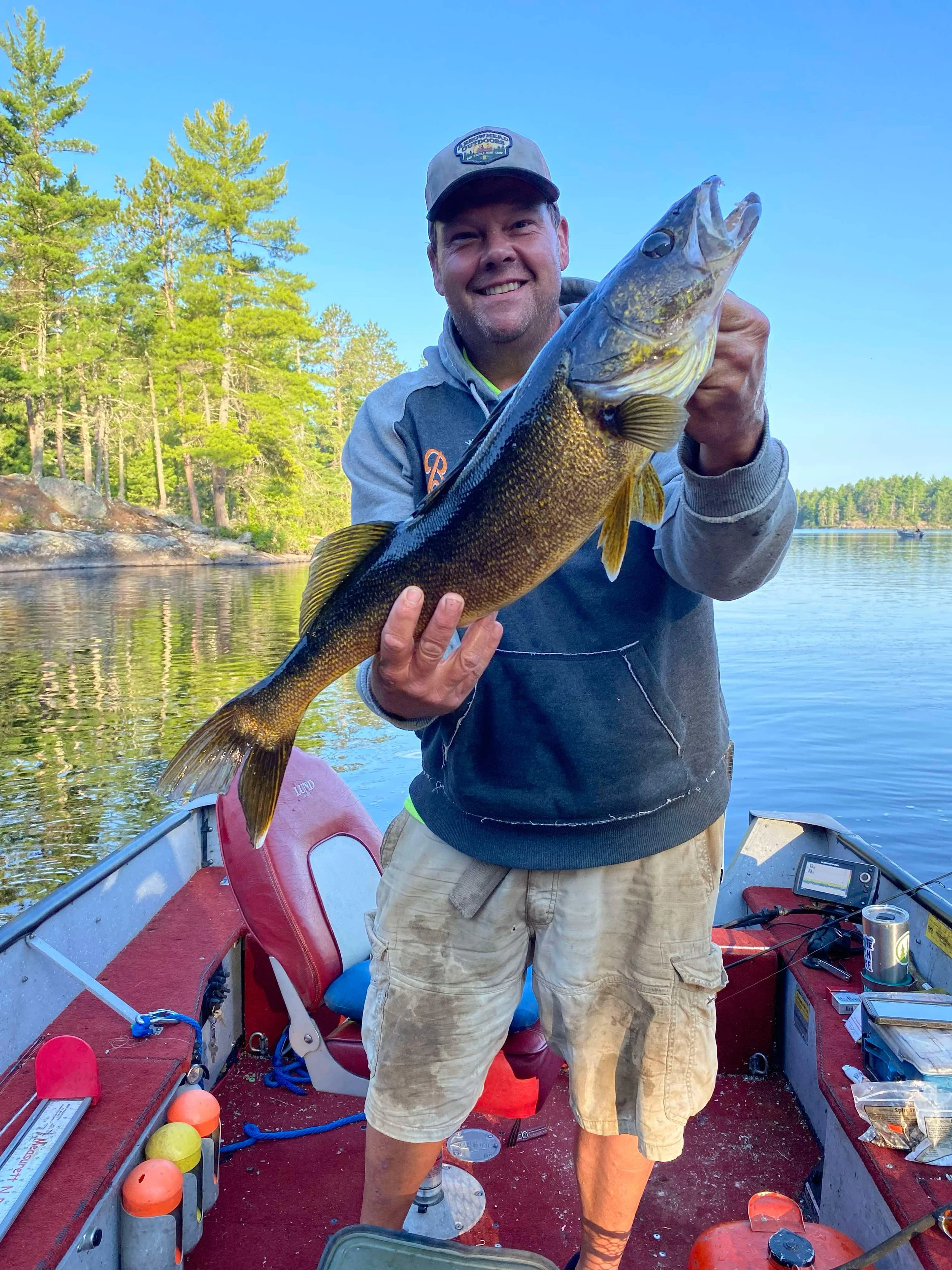 Angler holds giant walleye caught on jumbo leech in boat Ely MN, BWCA area, August 6 2024. Arrowhead Outdoors Ely MN fishing report with premium tackle, hunting gear & camping supplies available.