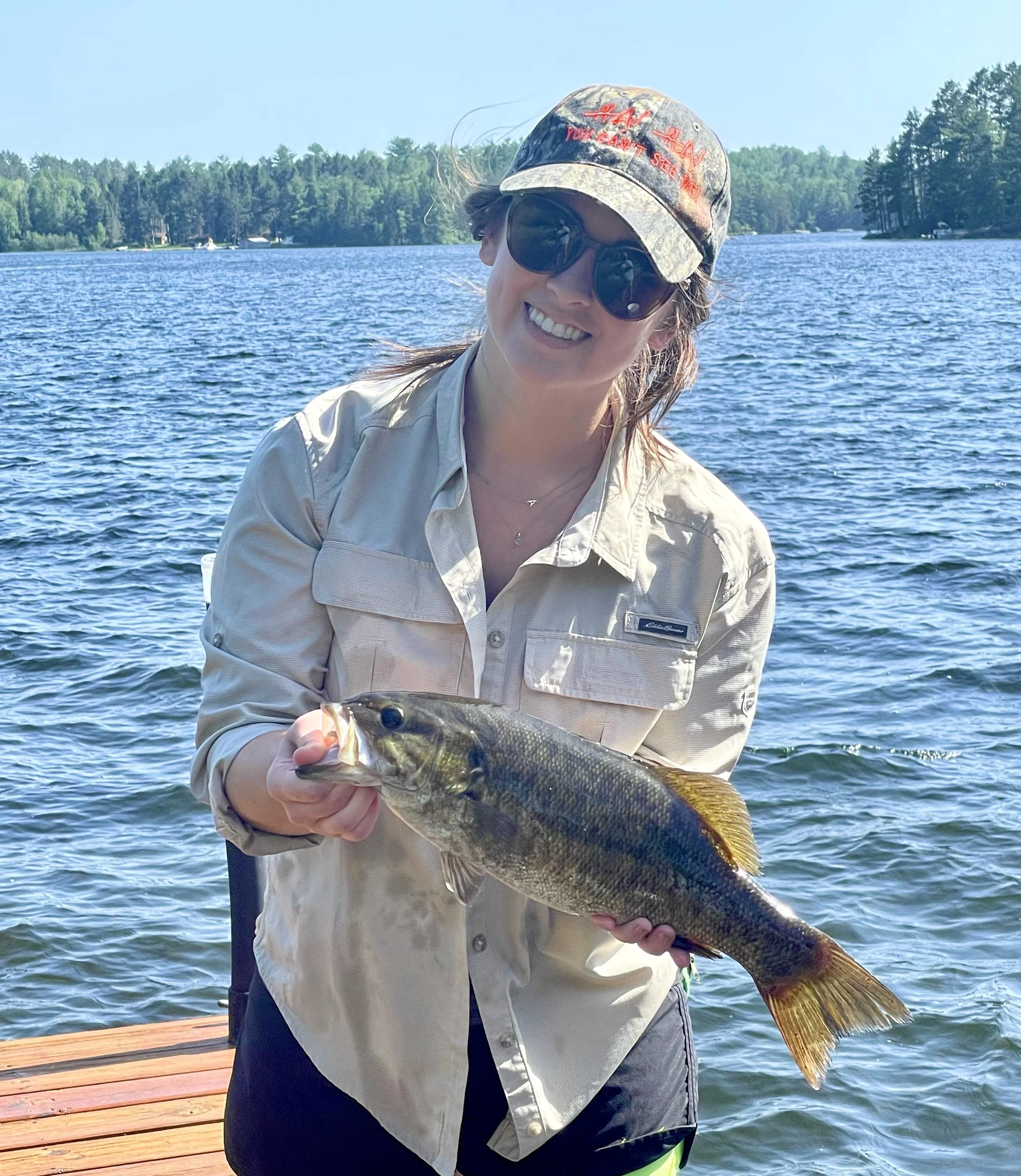 Angler holds smallmouth bass caught on leech off dock Ely MN, BWCA area, August 13 2024. Arrowhead Outdoors Ely MN fishing report with premium tackle, hunting gear & camping supplies available.