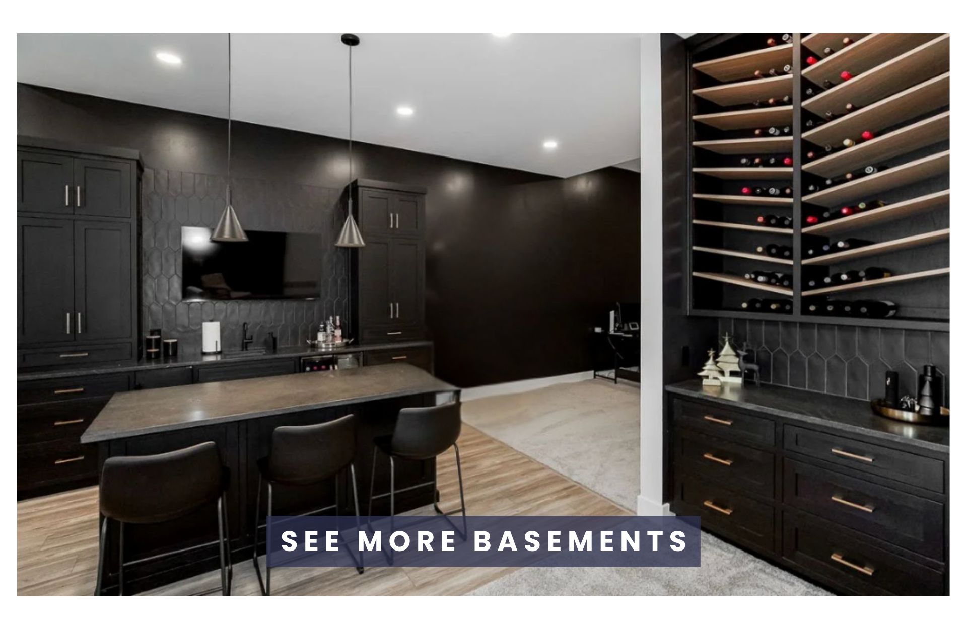Modern basement with black cabinetry, a wine rack, a kitchen area with a table and three chairs, and a flat-screen TV on a black textured wall.