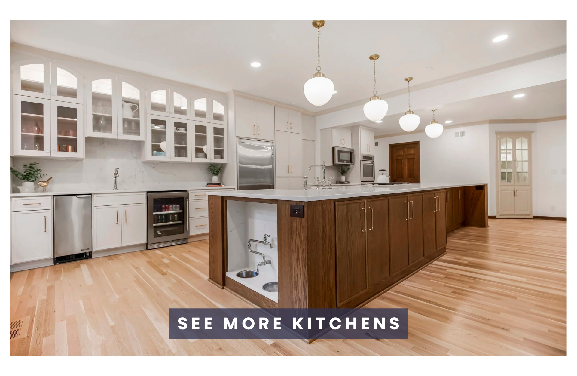 Modern kitchen with white cabinets, a large wooden island, pendant lighting, and hardwood floors.