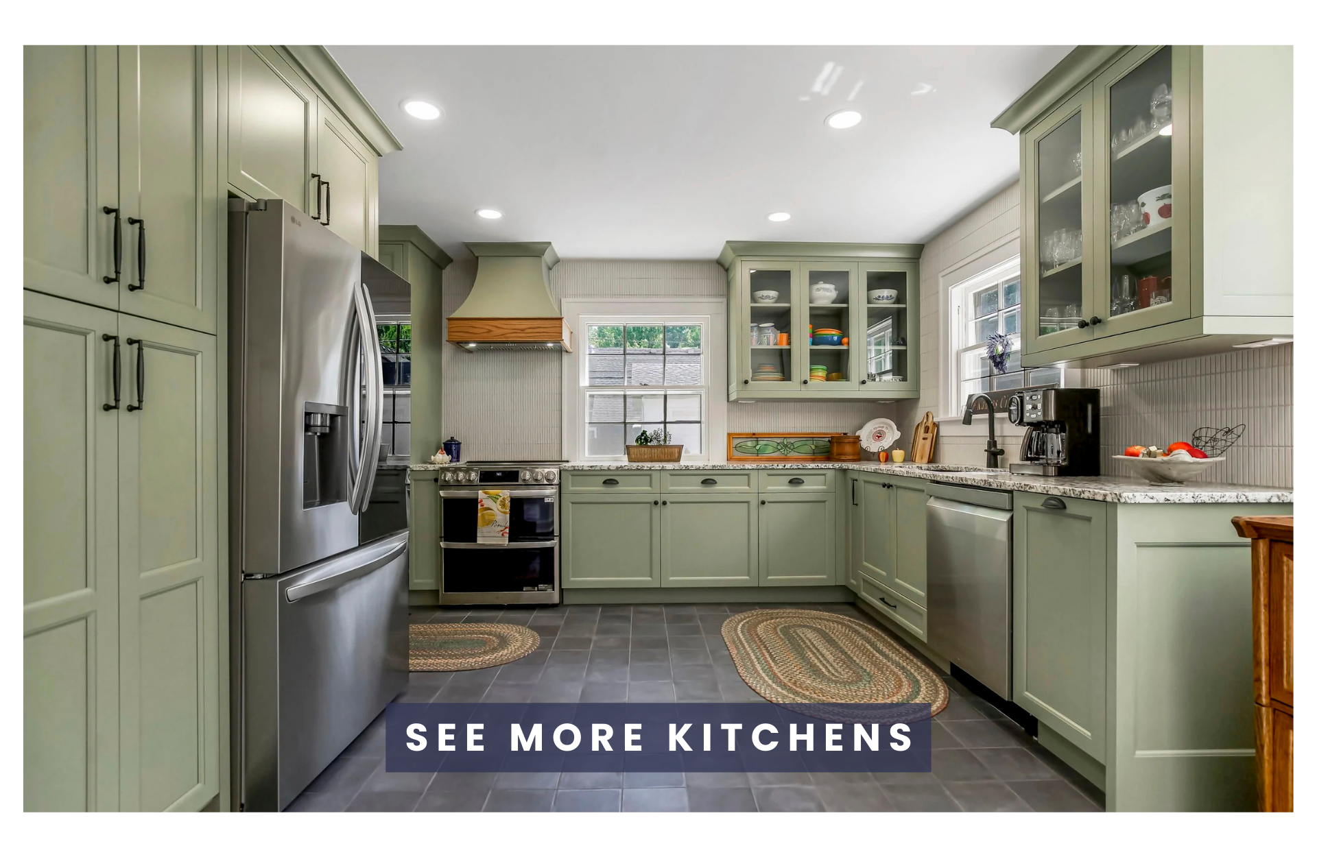 Bright kitchen with sage green cabinets, stainless steel appliances, granite countertops, and dark tiled flooring. Features include a window above the sink, glass-front cabinets, and a range hood.
