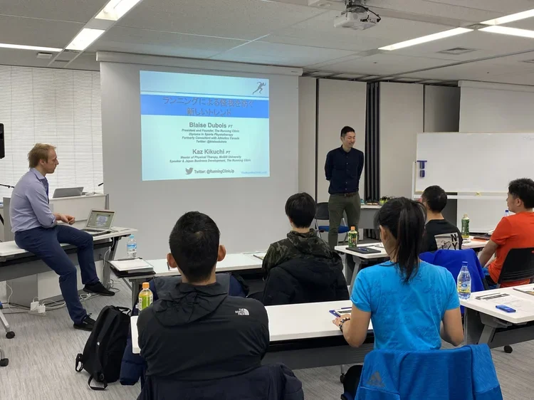 Kaz Kikuchi presenting on running at a conference