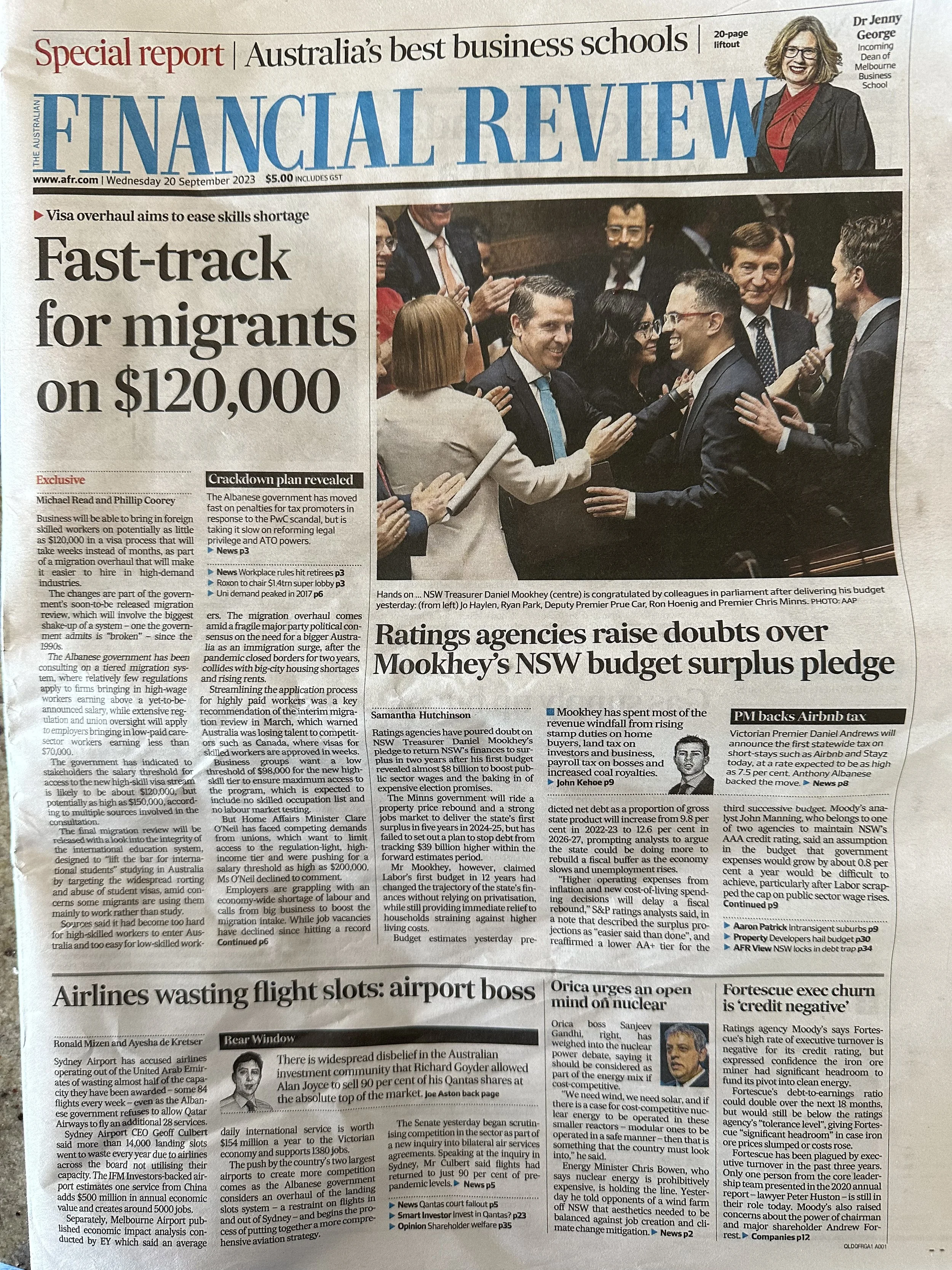 Front page of a newspaper called Financial Review with headlines about Australia's migration policy, NSW budget surplus, and ratings agencies' doubts. Contains photos of politicians and a small inset photo of an airline at an airport.