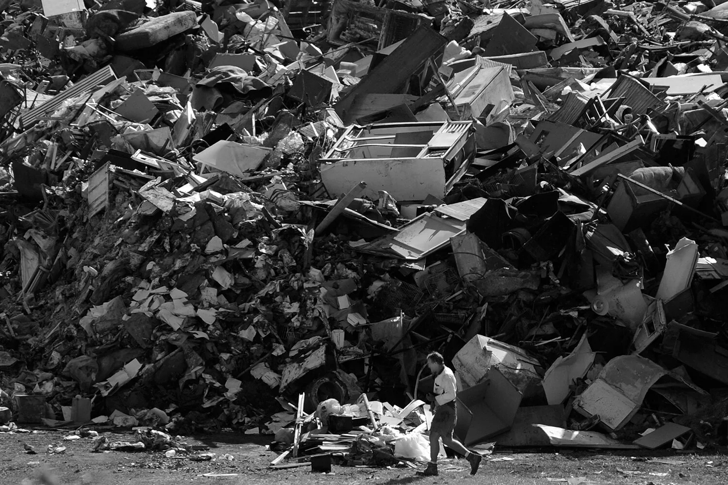 A Brisbane City Council worker is dwarfed by a mountain of houshold debris dumped next to the sports grounds at the Victoria Park Golf Club following this weeks devastating floods in Brisbane, Monday, Jan. 17, 2011.