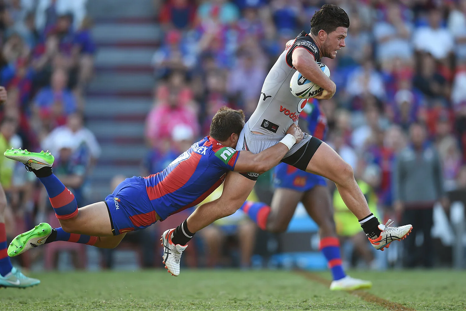 Tyrone Roberts of the Knights makes a flying tackle on Chad Townsend of the Warriors during their round 1 NRL match between the Newcastle Knights and the New Zealand Warriors at Hunter Stadium in Newcastle, Saturday, March 7, 2015.