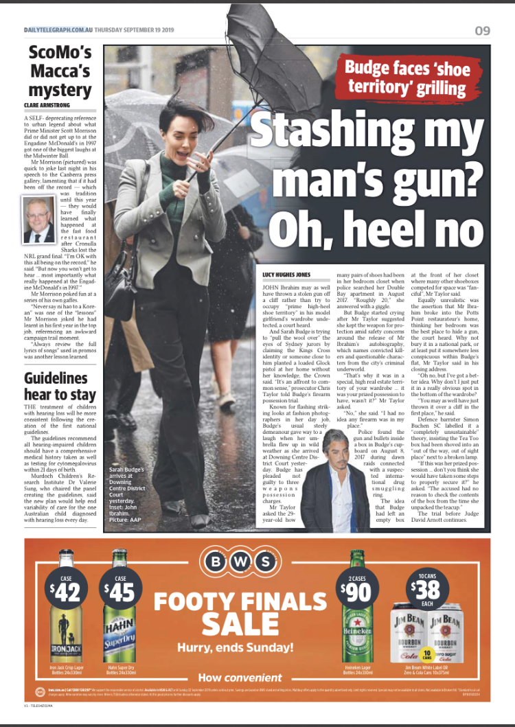 A woman standing outside in the rain, holding an umbrella and talking on a cell phone. The background shows a wet street with rain pouring down.