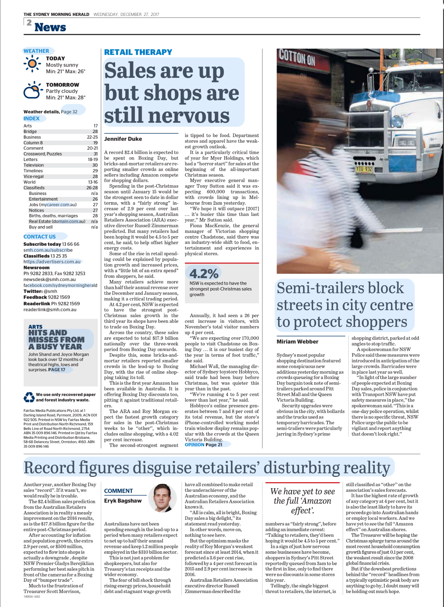 Close-up of a street scene with a semi-trailer truck in motion and blurred pedestrians crossing the street.