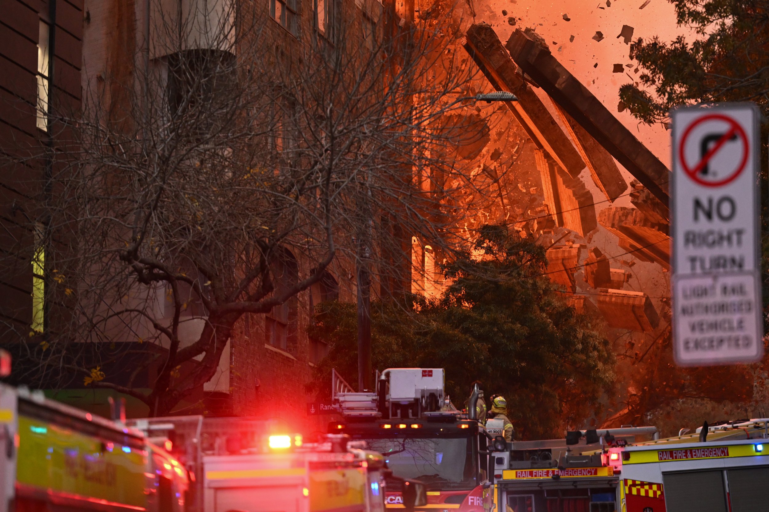 The front wall collapses into the street during a building fire in the Central Business District of Sydney, Thursday, May 25, 2023. One hundred and twenty fire fighters and 30 trucks attended the scene taking more than 5 hours to bring the blaze unde