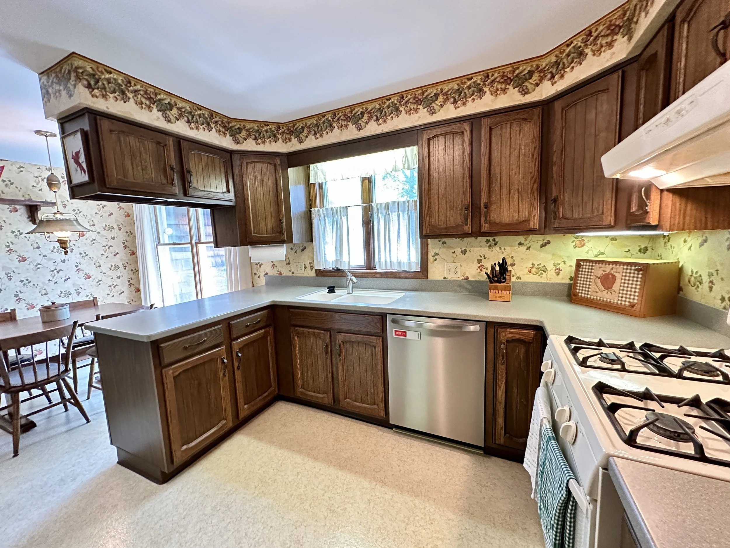 Kitchen has durable Corian countertops, abundant cabinetry, a pantry & plenty of workspace for everyday living & entertaining