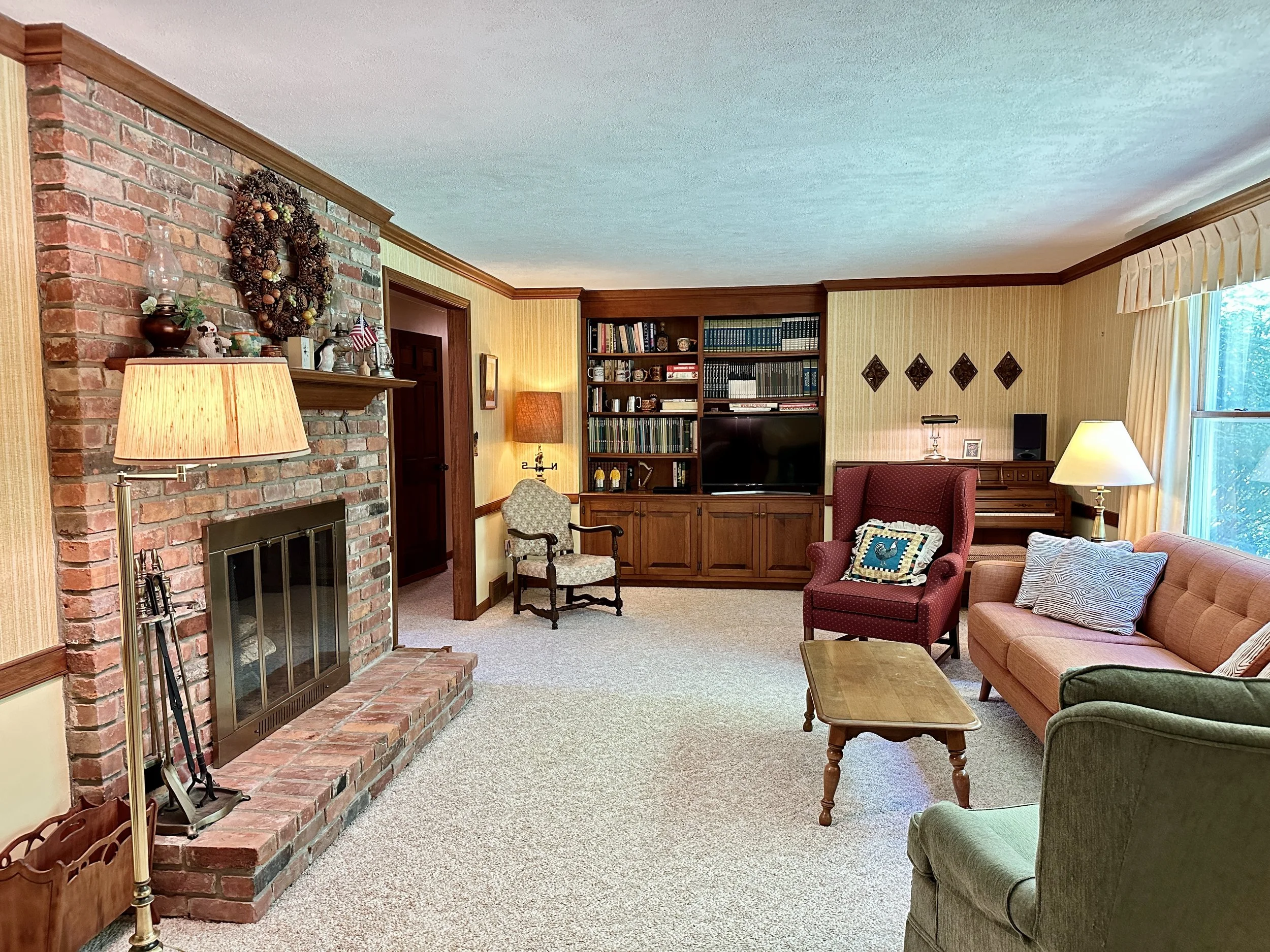 The formal living room is anchored by a cozy wood-burning fireplace 