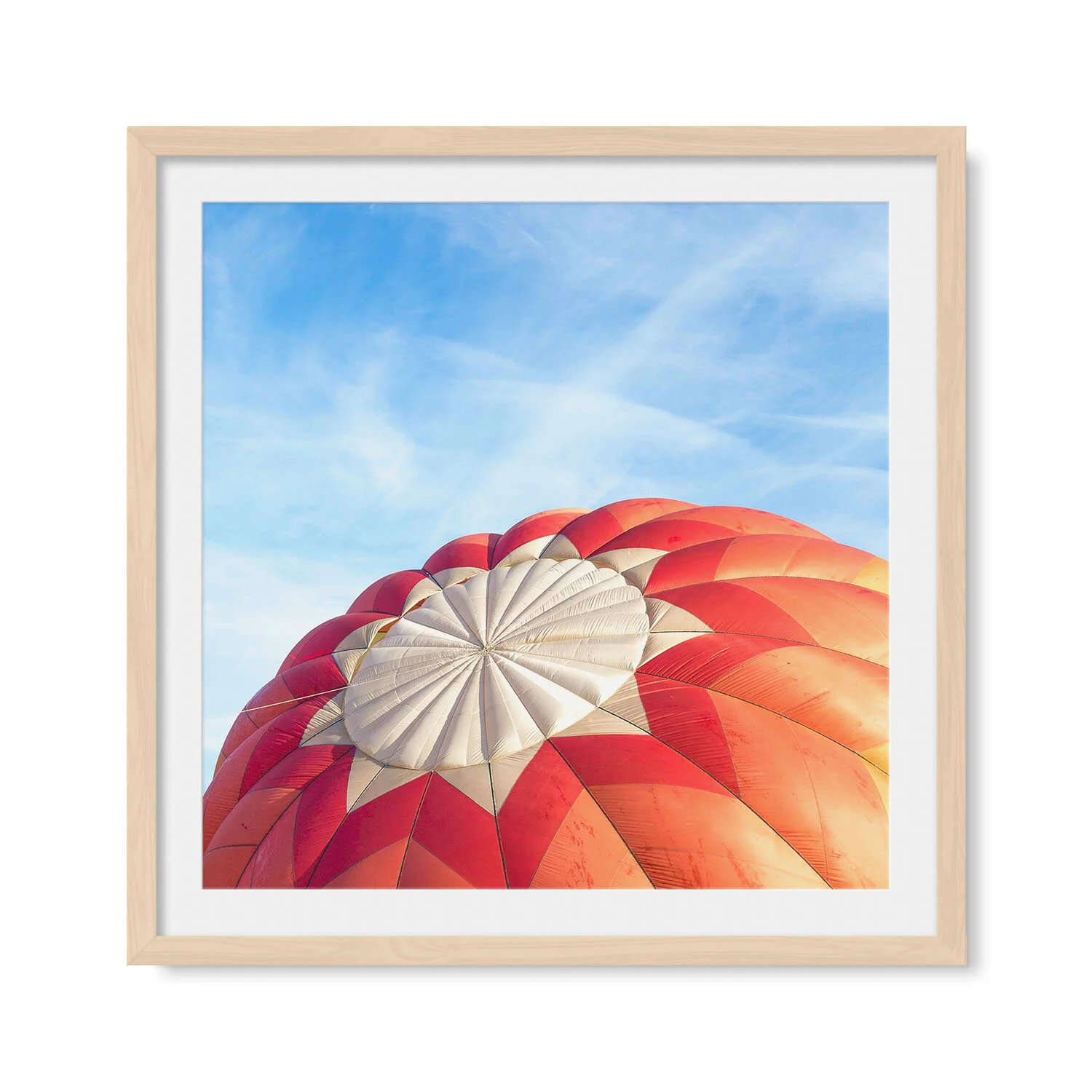 Light maple solid hardwood framed square fine art photography of two pink, red and golden orange hot air balloons against a blue sky.
