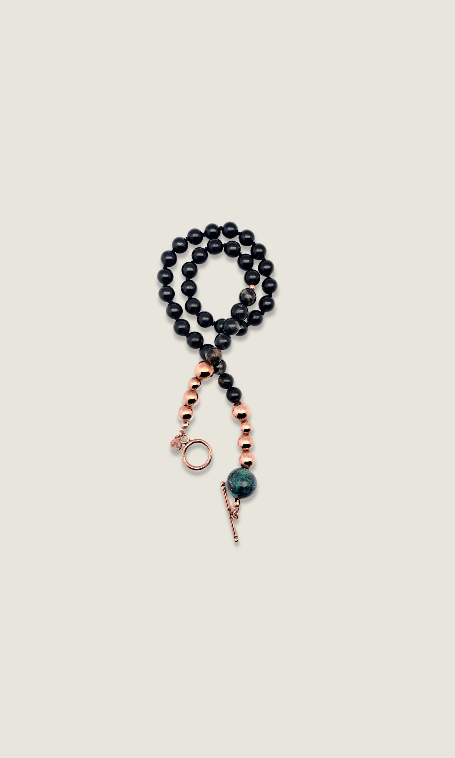 Black and blue with copper beaded necklace and toggle clasp displayed in a coil shape