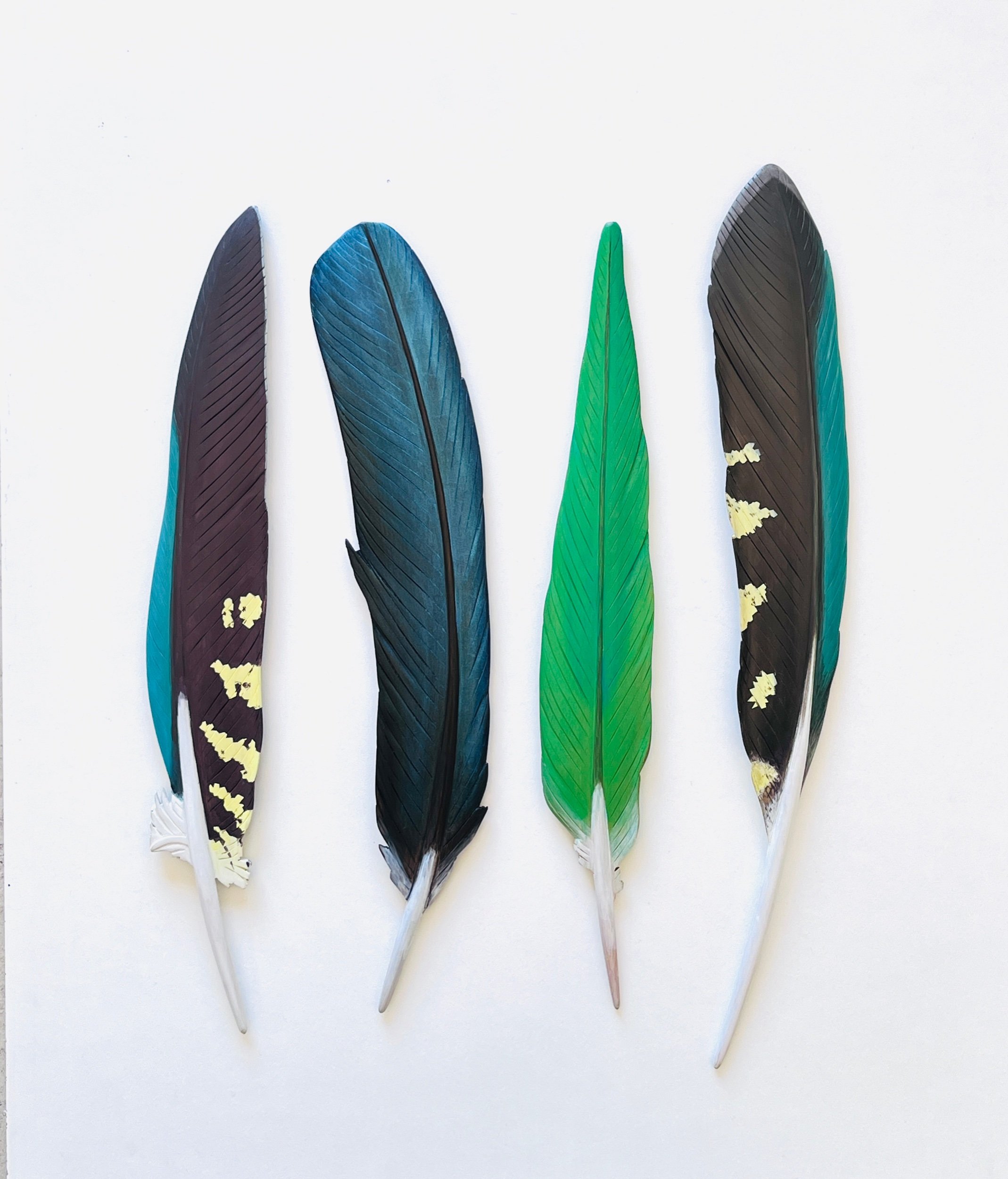 Green feathers of native New Zealand birds. Carved wood wall art by Claire Jensen Opunake.