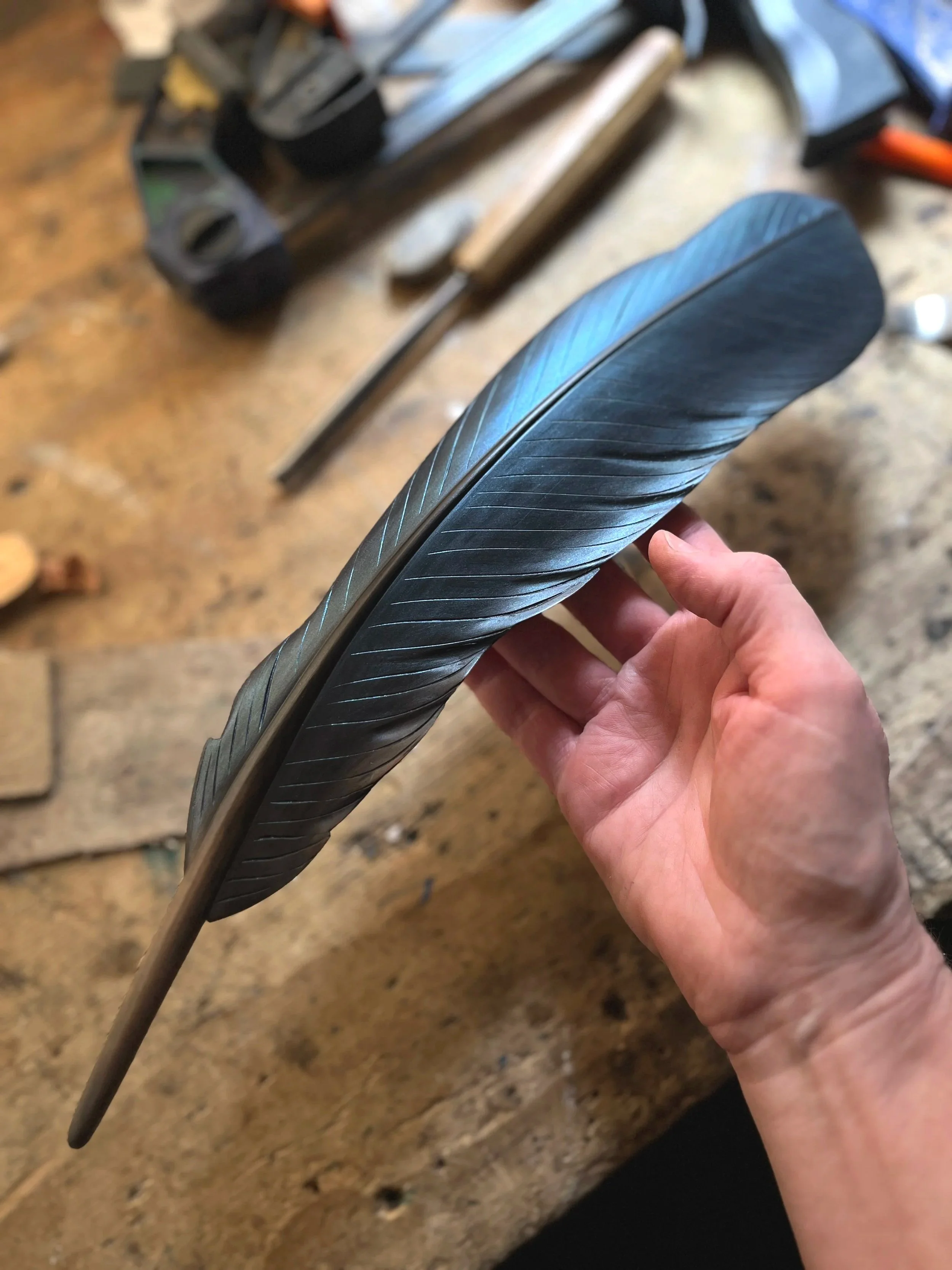 Iridescent blue tui feather art by Claire Jensen. Carved native New Zealand wood with acrylic paint. Tui art by Claire Jensen Opunake. 