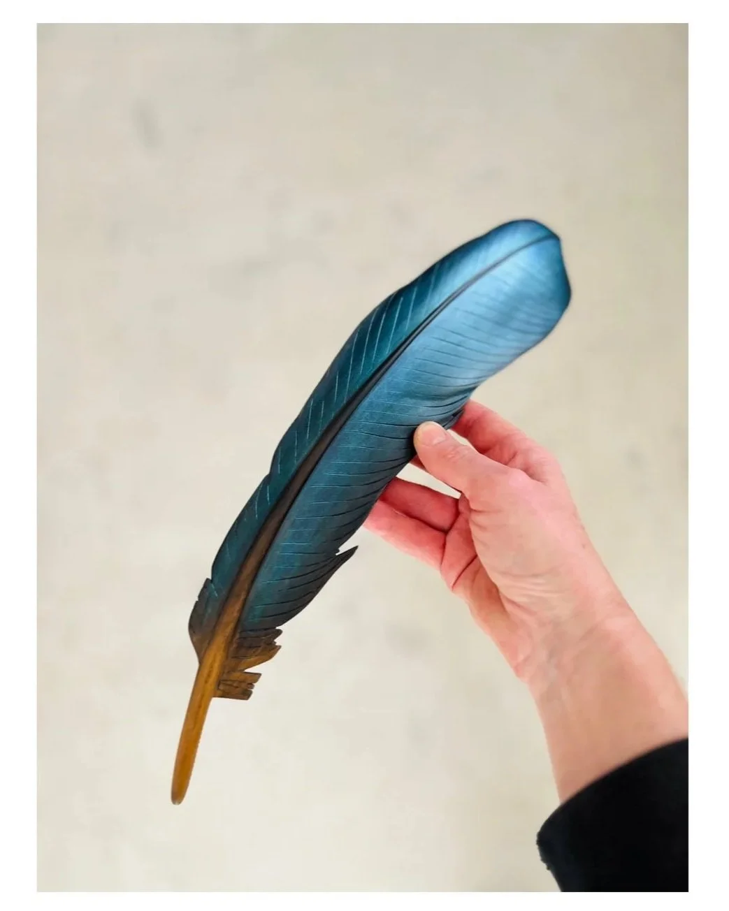 tui art carved feather with iridescent blue colour by claire jensen.
