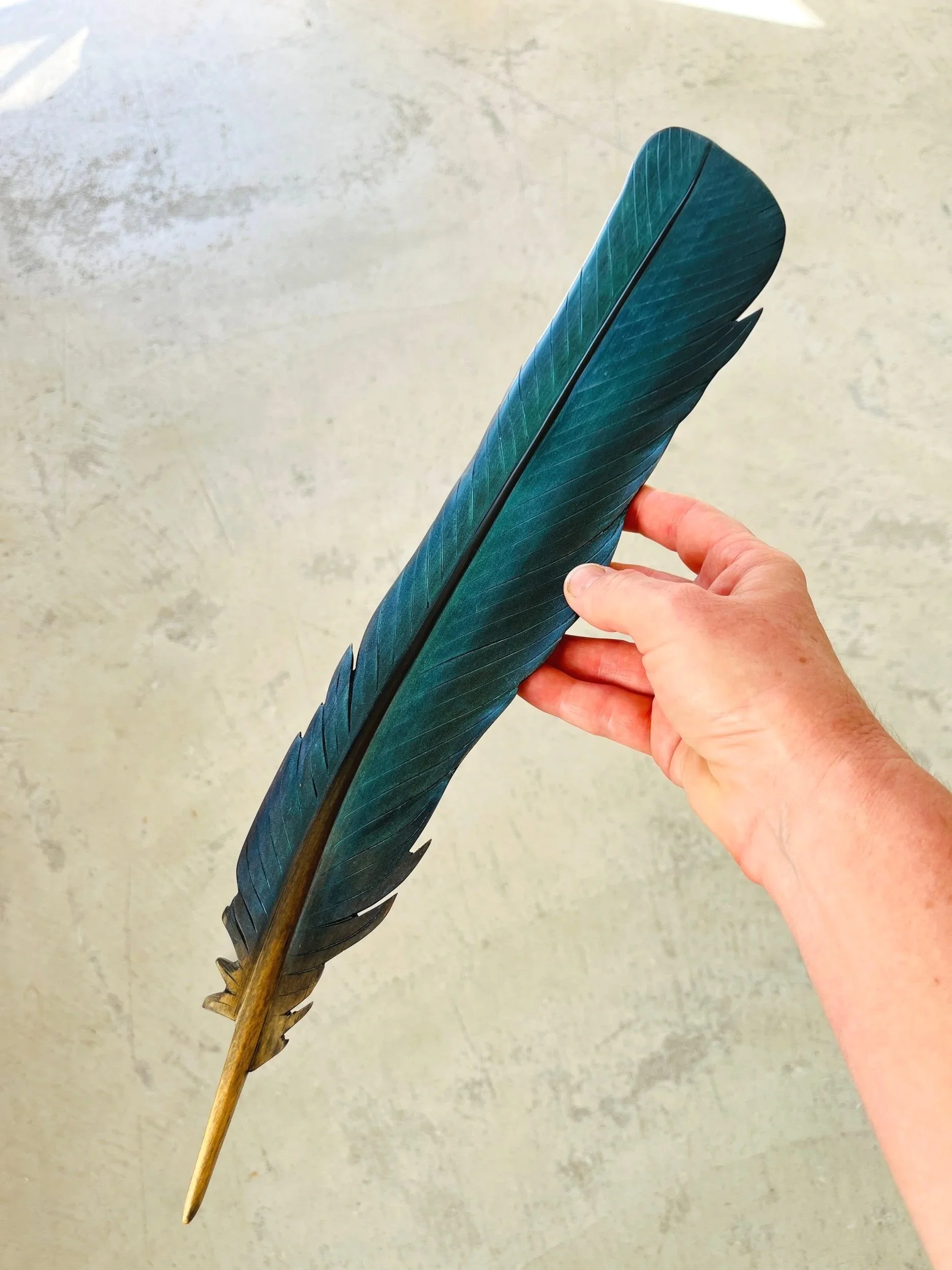 tui art carved feather with iridescent blue colour by claire jensen.