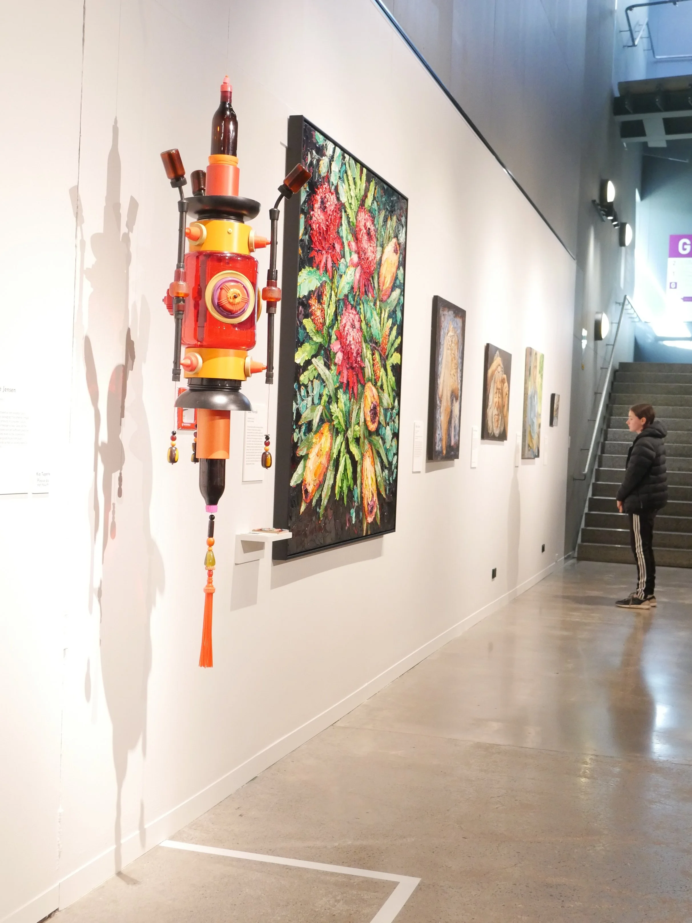 Contemporary sculpture by Claire Jensen in the Homework, Taranaki artists, exhibiton Puke Ariki Museum. Colourful suspended sculpture called 'Reverence', made from collected plastic packaging.