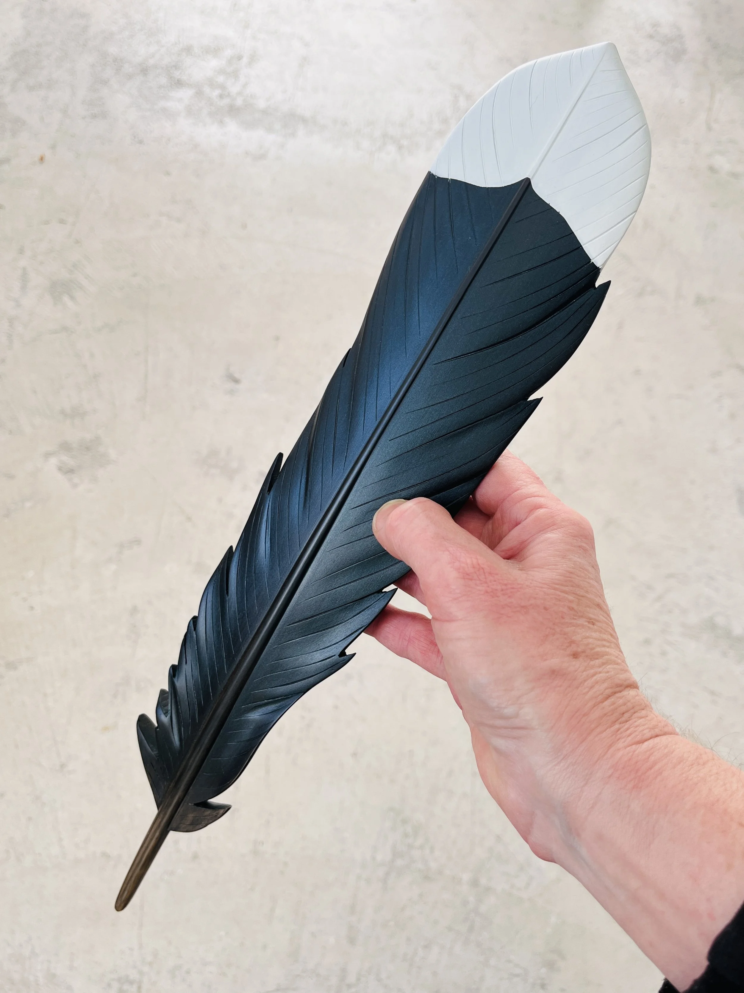huia feather carving held in hand claire jensen.JPEG
