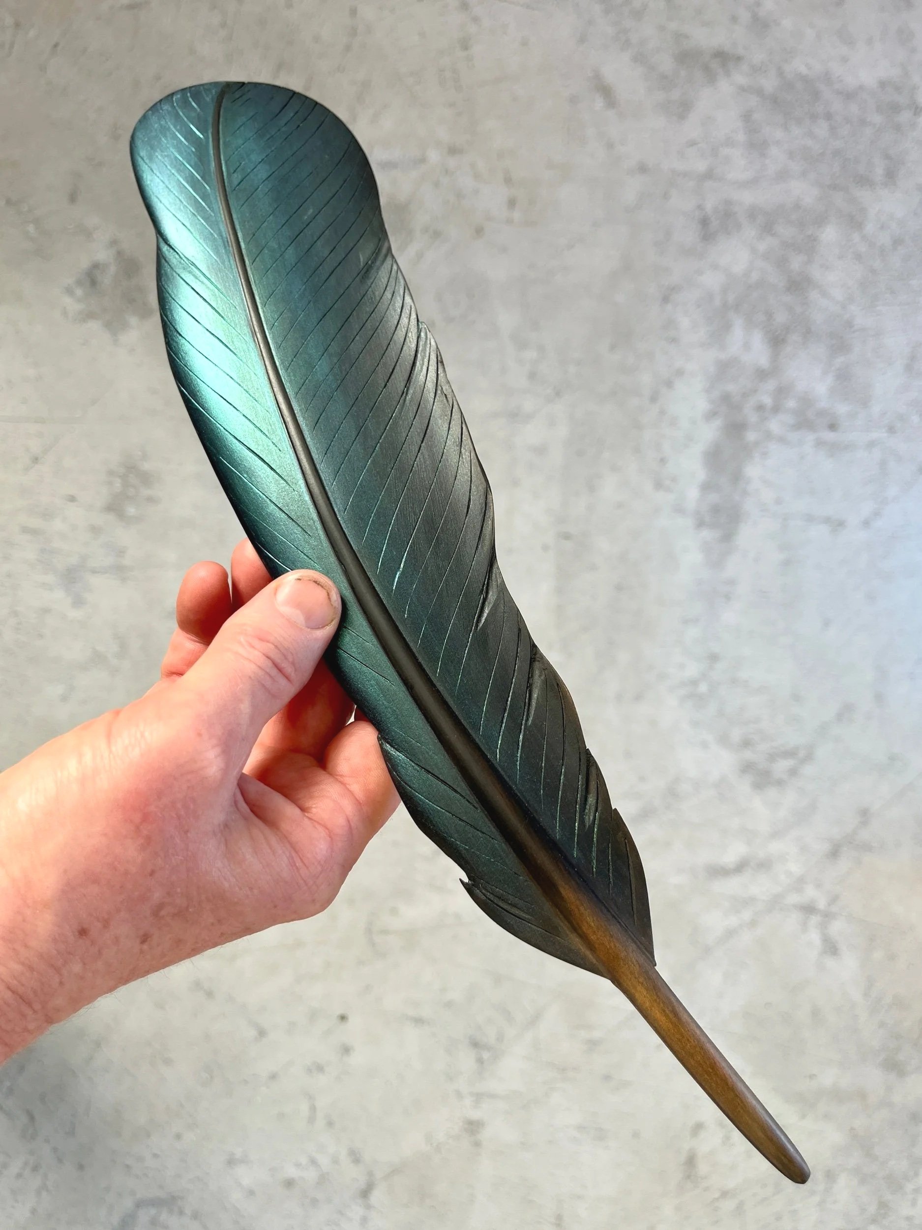 iridescent blue green tui feather art by taranaki artist claire jensen