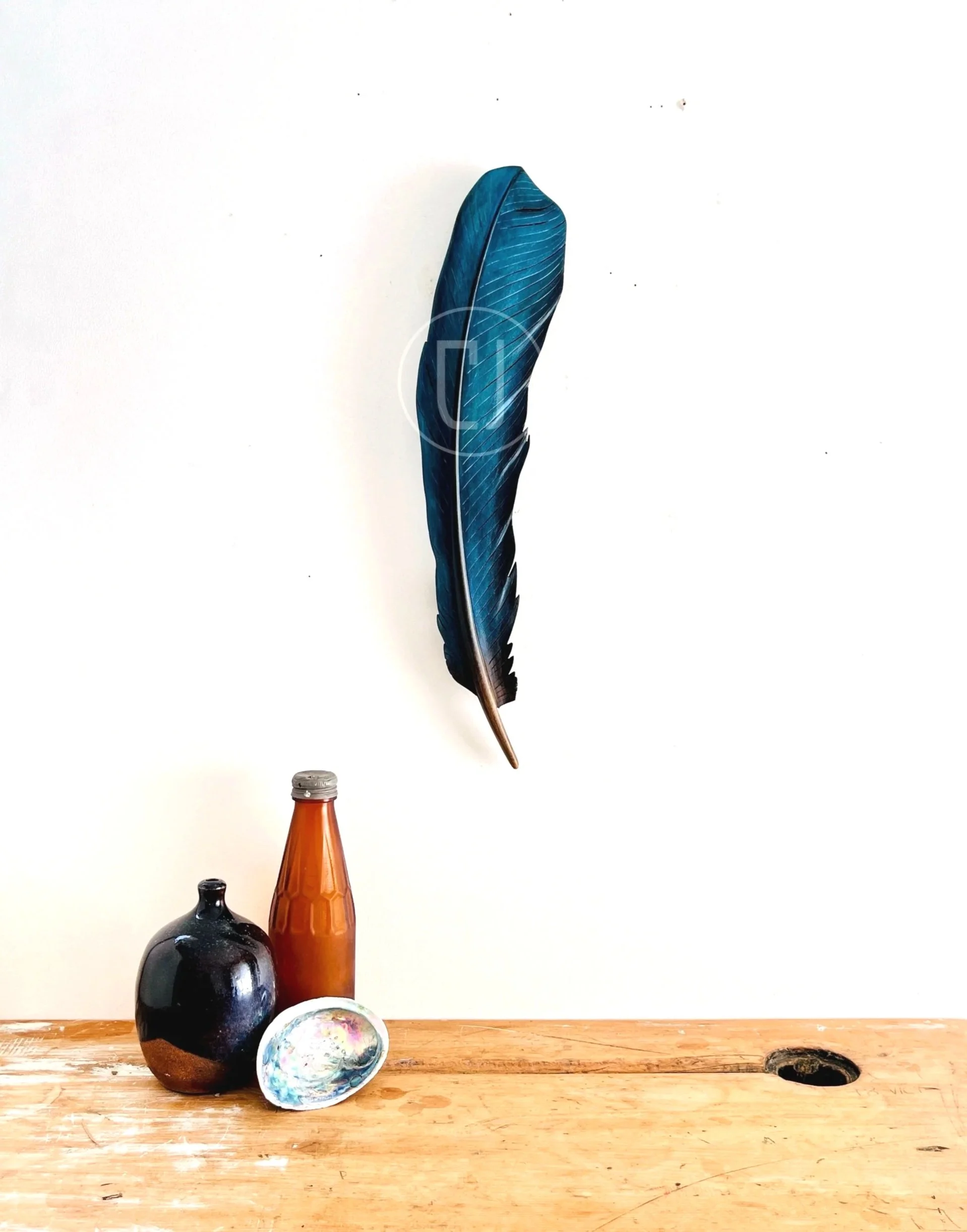 tui art carved feather with iridescent blue colour by claire jensen.