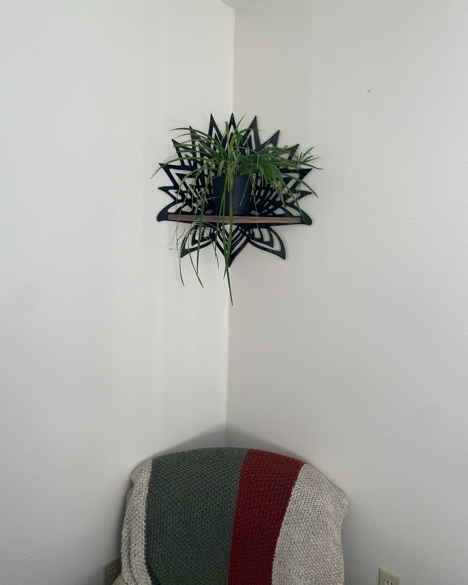 Photo of Creative Combinations Montana's Thousand Petal Lotus Steel and Wood Corner Shelf, finished with a black magic patina finish and cedar wood shelf.