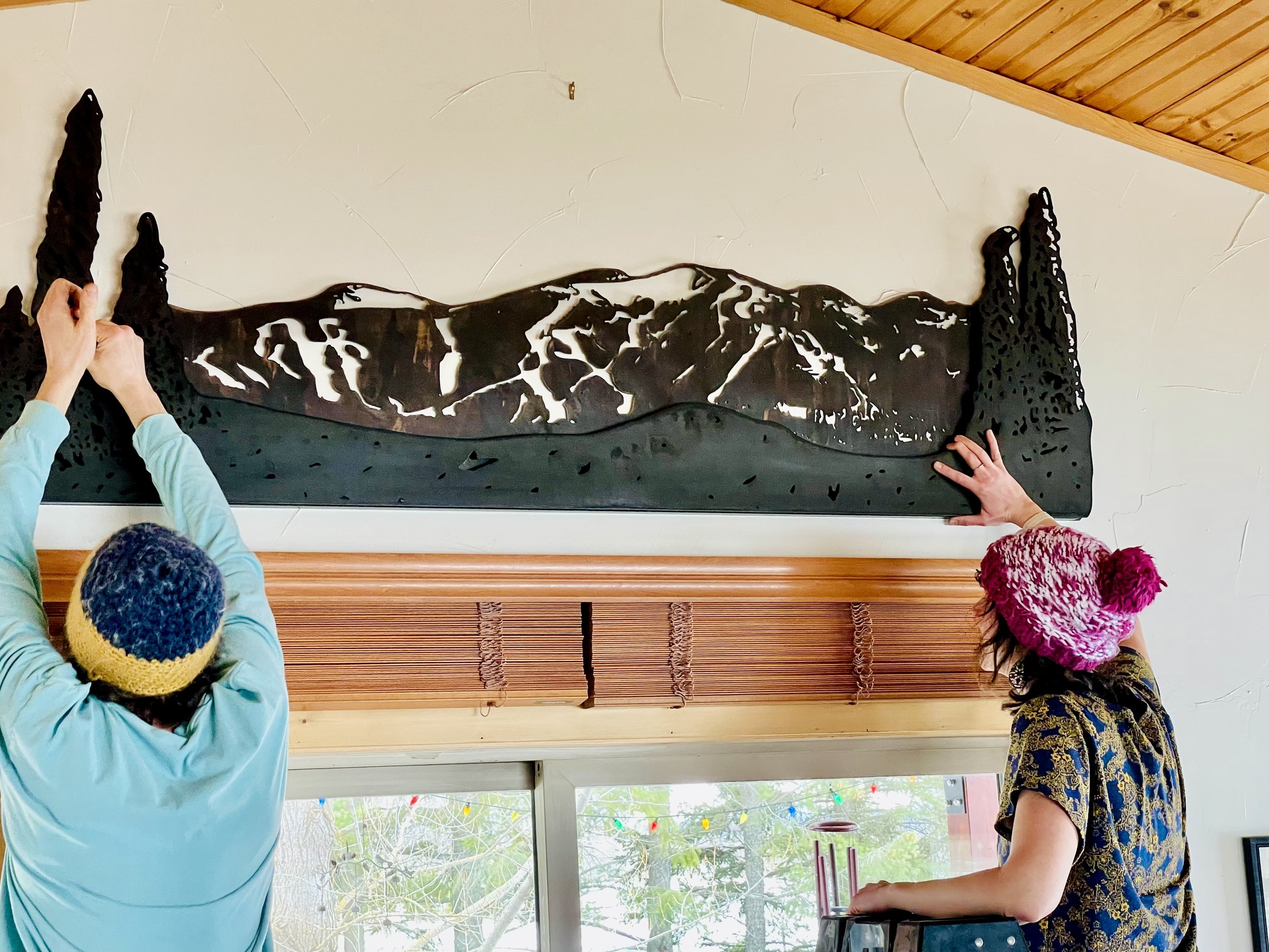 Montana mountain metal art home installation photo of owners Nathan Stoltzfus and Kelsey Holmes in Whitefish Montana.