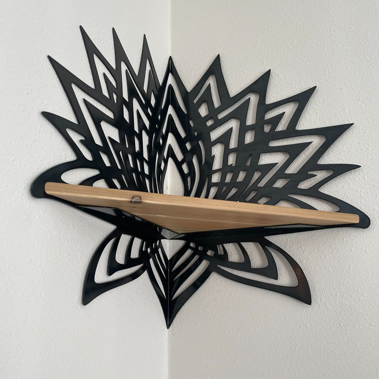 Photo of Creative Combinations Montana's Thousand Petal Lotus Steel and Wood Corner Shelf, finished with a black magic patina finish and cedar wood shelf.