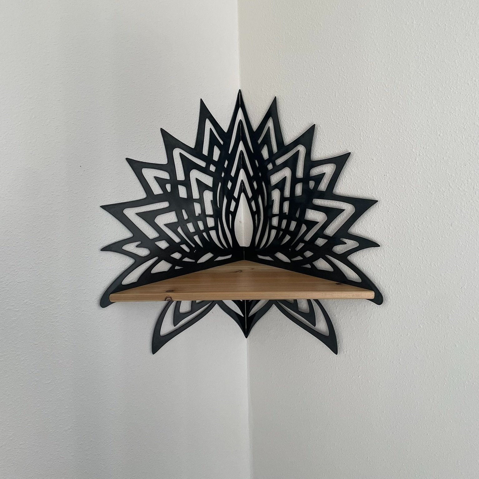 Photo of Creative Combinations Montana's Thousand Petal Lotus Steel and Wood Corner Shelf, finished with a black magic patina finish and cedar wood shelf.