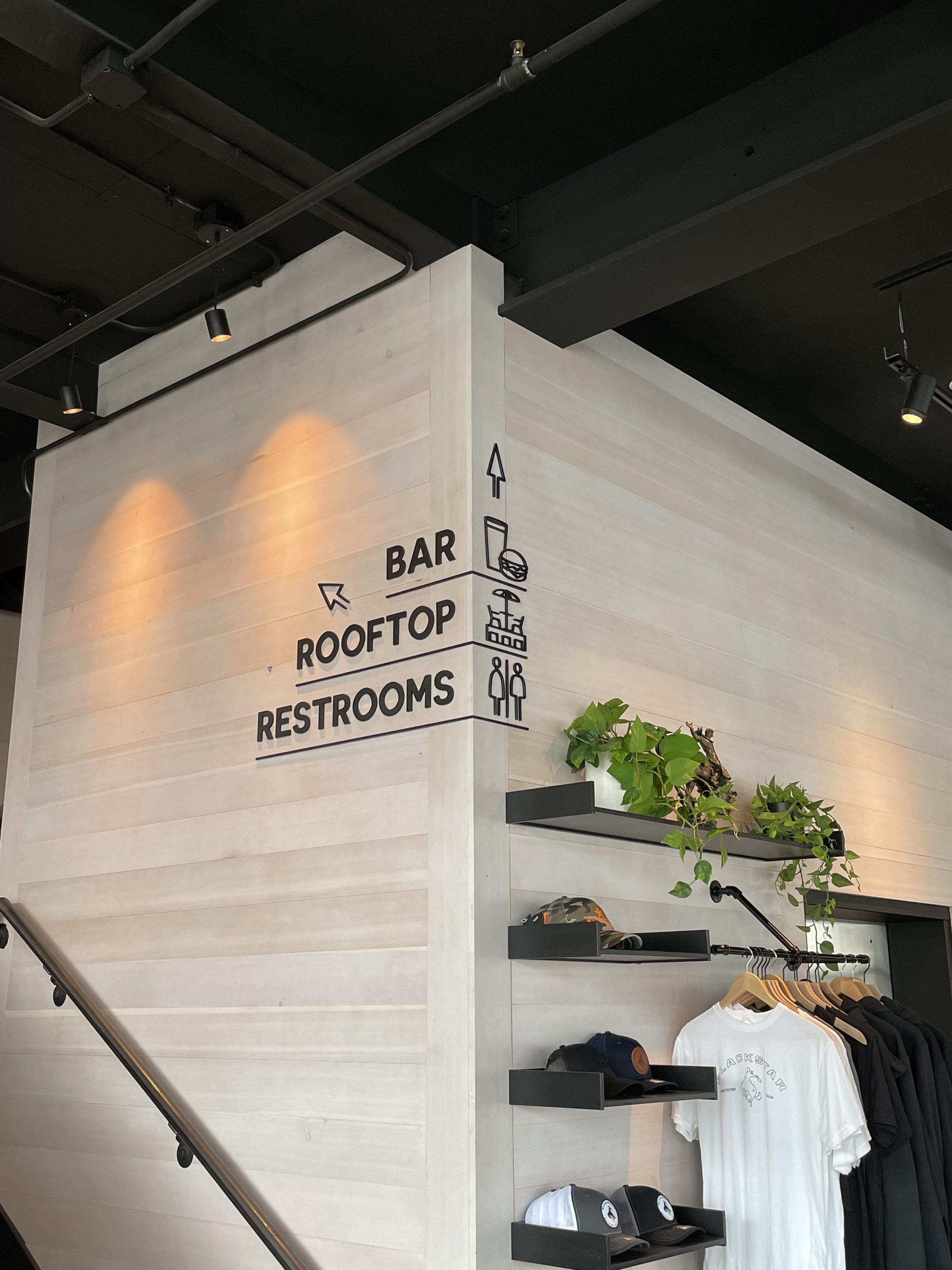 Custom steel information graphic signs with directional arrows indicating the locations of a bar, rooftop, and restrooms inside a Blackstar in downtown Whitefish Montana, fabricated and installed by Creative Combinations Montana.