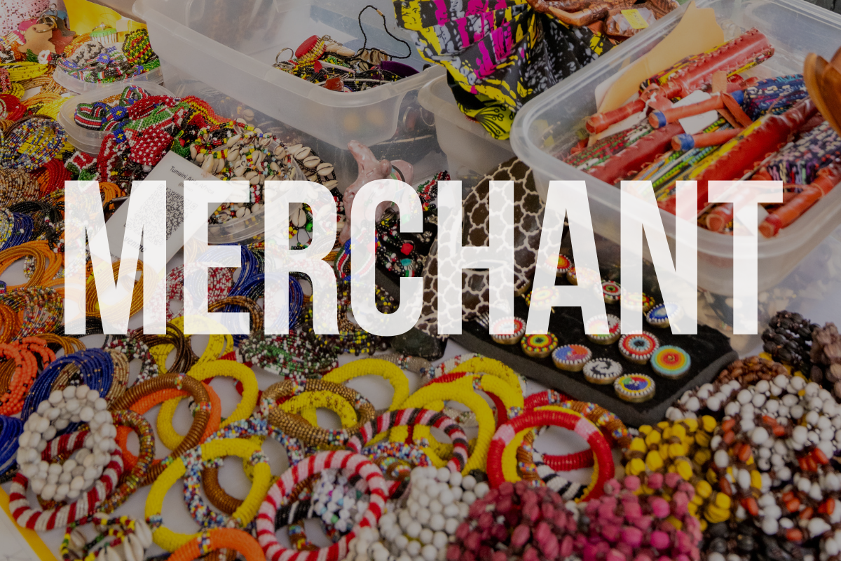 A table filled with colorful handmade jewelry, beads, and accessories at a merchandise stall.