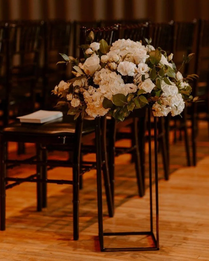 WANT TO HEAR A SECRET!?
Both the tall stand arrangements and the short, compote-style centerpieces are the best way to decorate your aisle AND your tables with out breaking the bank. π Sure, they may be more expensive per table, but they are easily