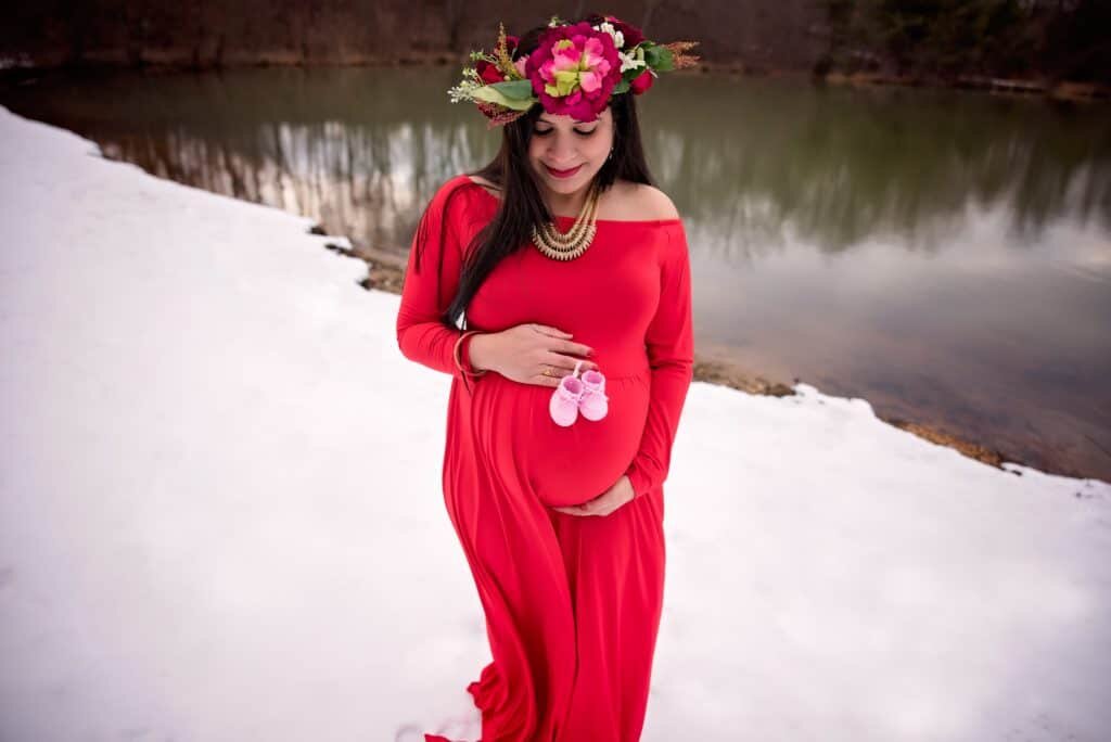  Madhu’s red maternity dress really stands out in the white snow    “We like maternity shoots with images of couple being very close, so we can feel the connection and emotion. We like them as natural as possible.”, said the couple. 