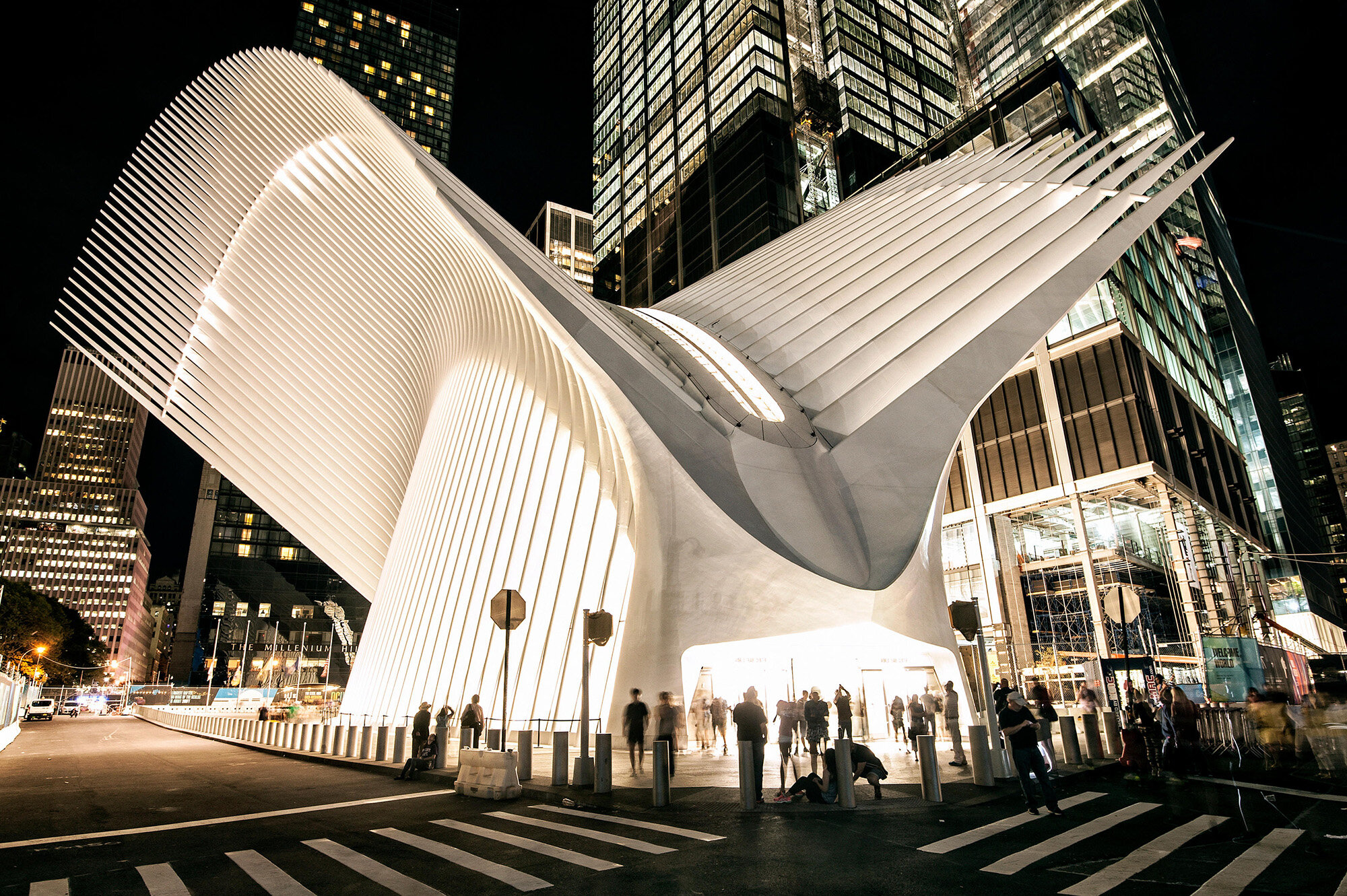 Exterior of Oculus at World Trade Center at night. A unique architectural building with various 'wings' extending from this rounded building'