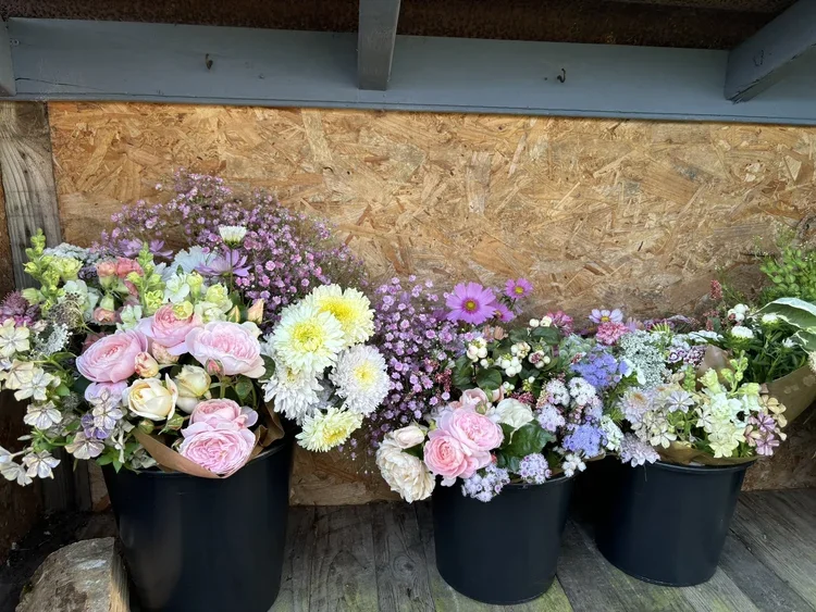 Buckets of mixed flowers for a DIY wedding