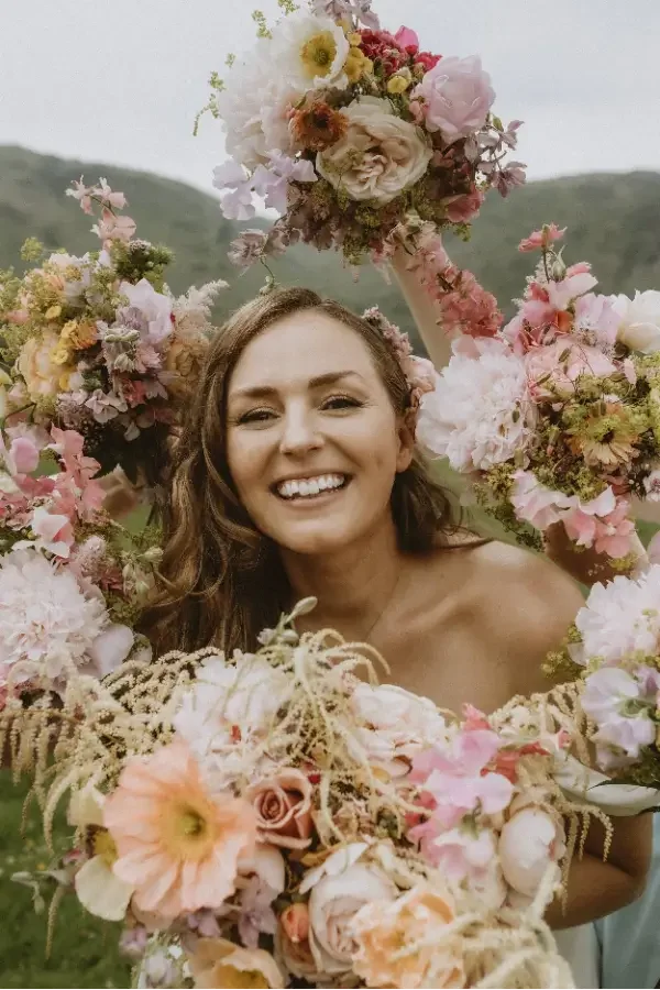  Woman smiling surrounded by wedding flowers 