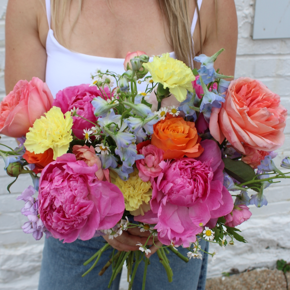Woman holding a colorful bouquet of fresh seasonal flowers from Rudy's Flower Truck in St. Louis.