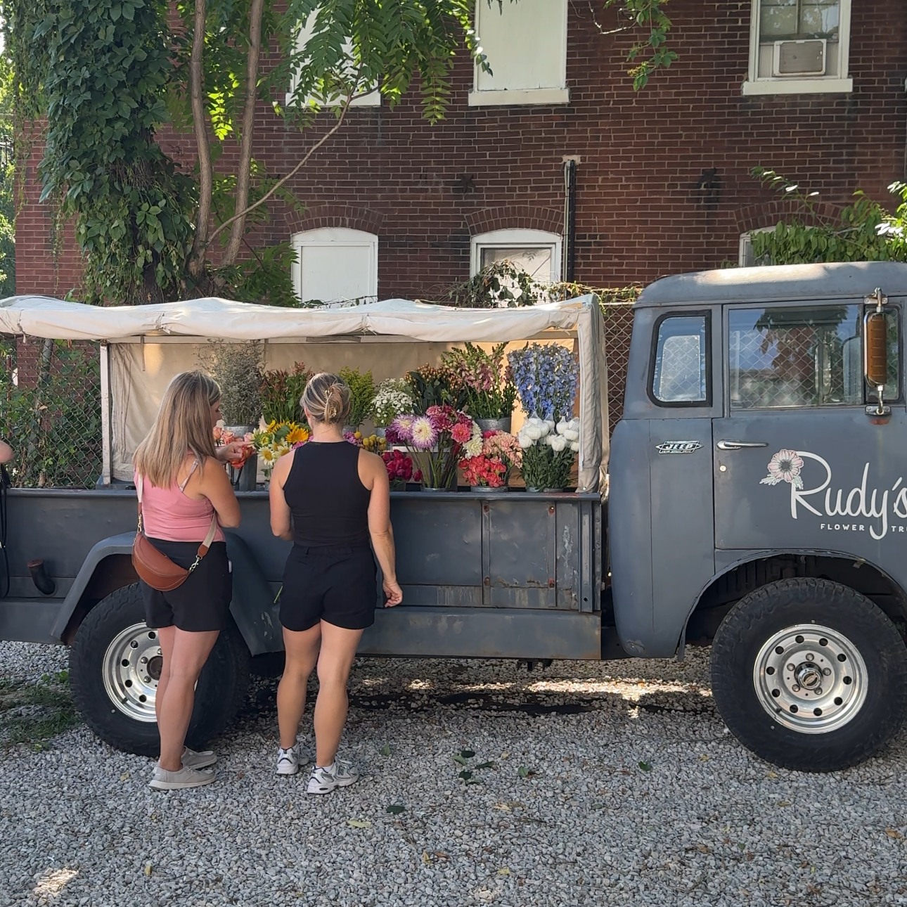 Customers visiting Rudy's Flower Truck during a summer event with local coffee in St. Louis.