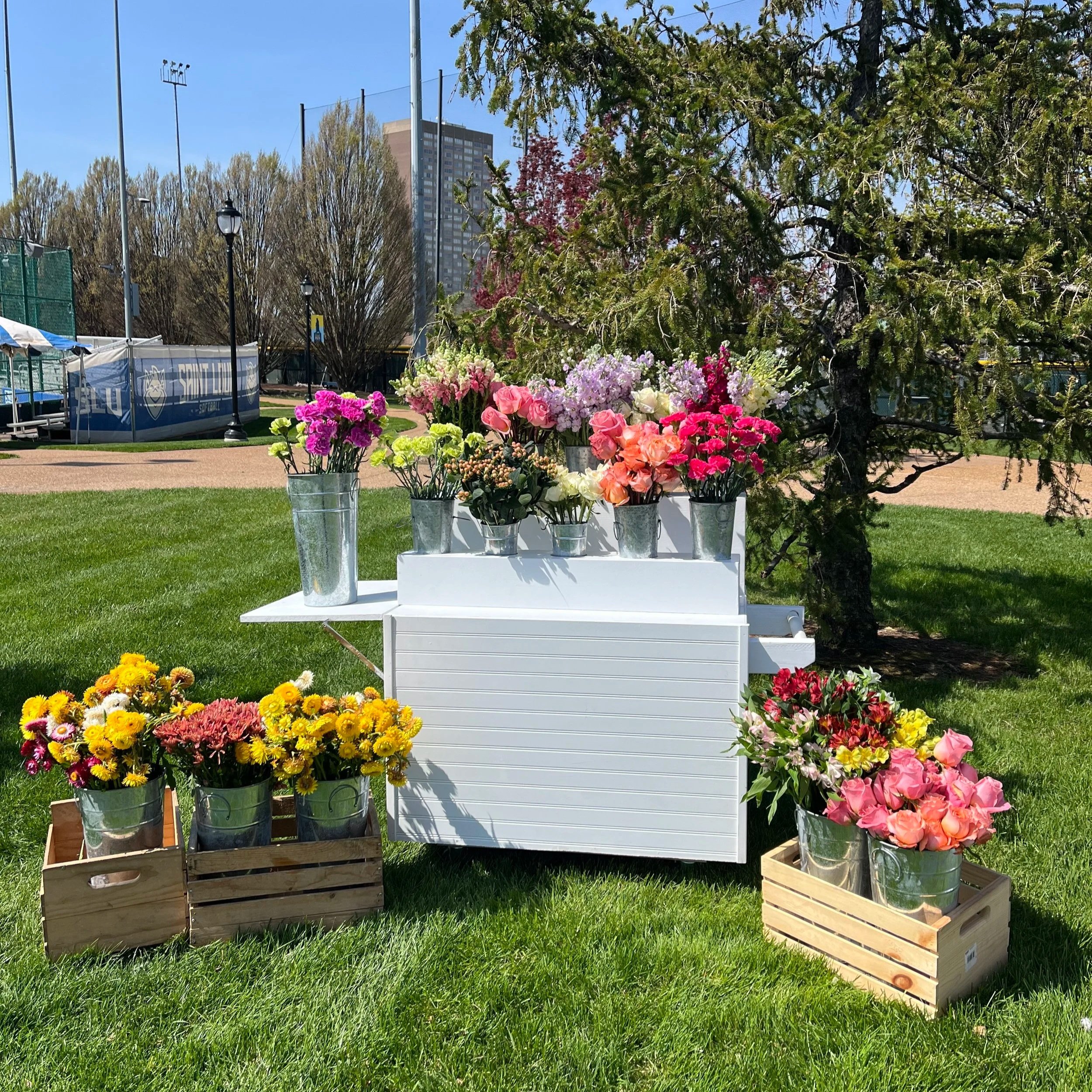 White flower cart rental decorated with colorful fresh flowers for a St. Louis event.