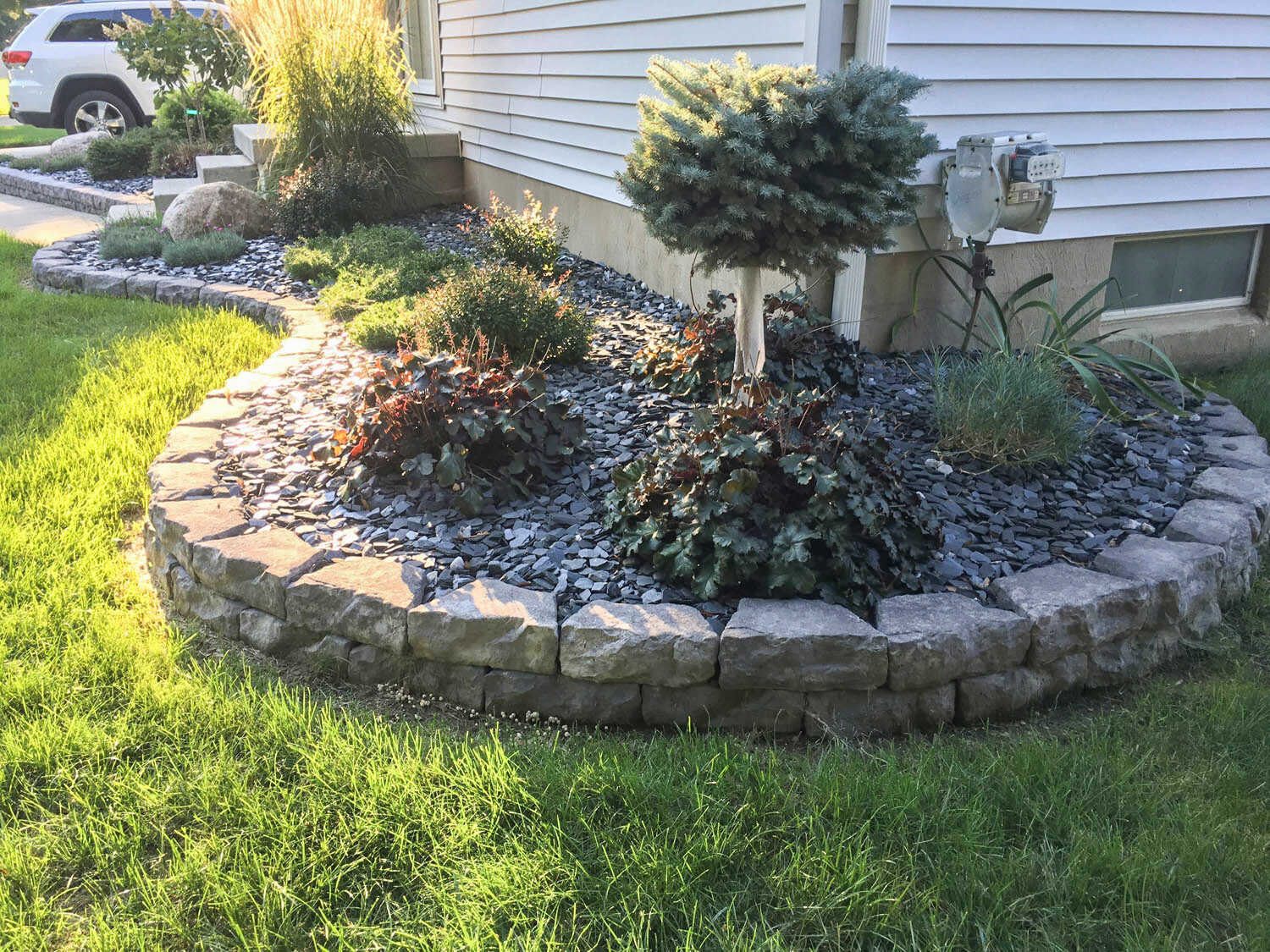  garden bed with retaining wall with shrubs | Holly MI | H &amp; M Landscaping 