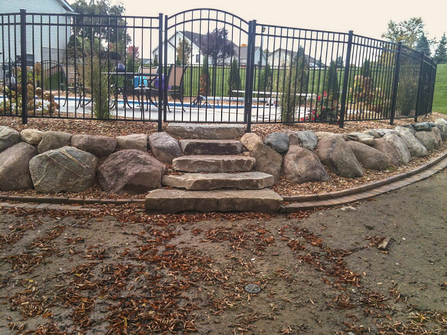  rock wall and rock steps surrounding a pool | H&amp;M Landscaping 