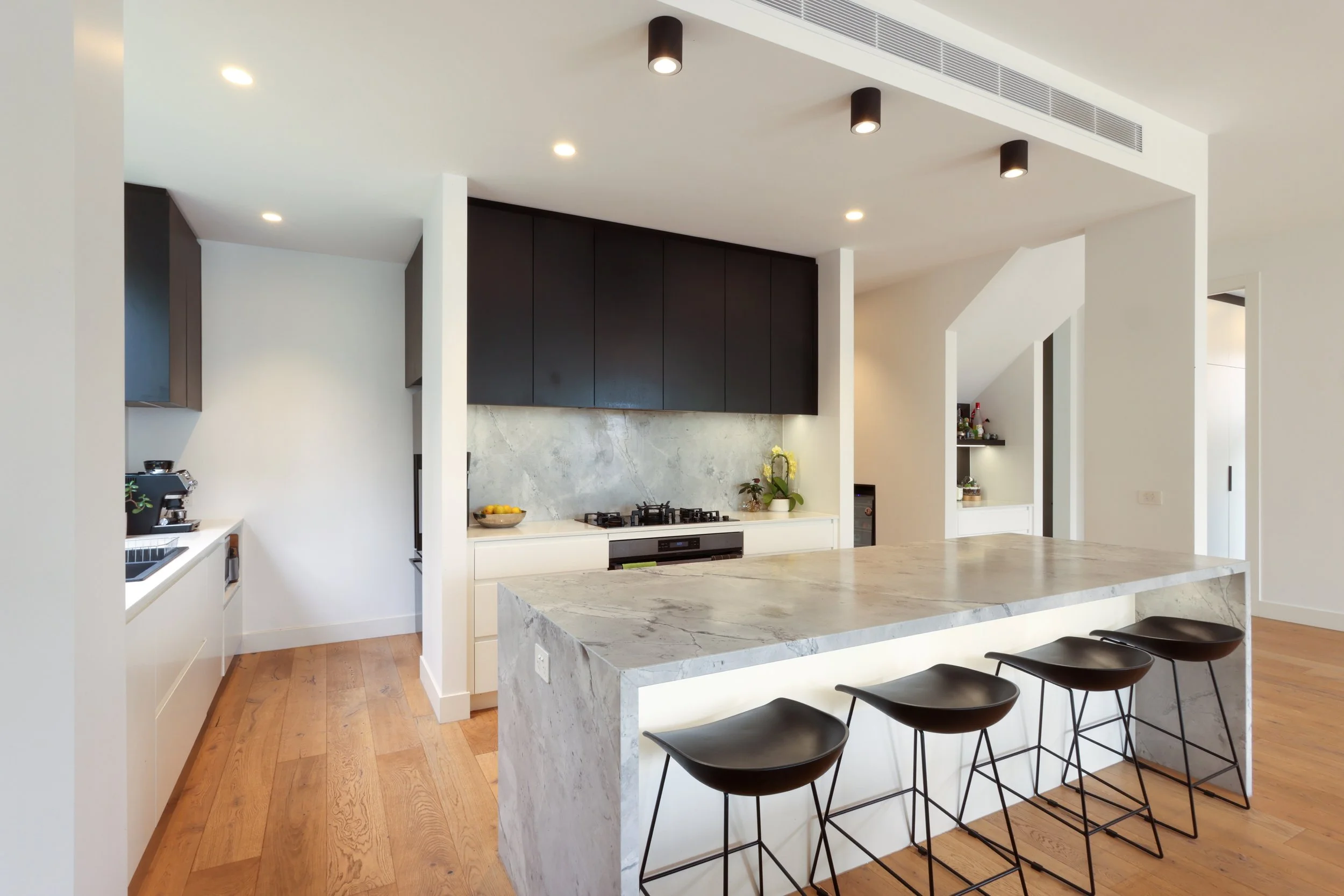 modern kitchen wtih marble bench and timber flooring