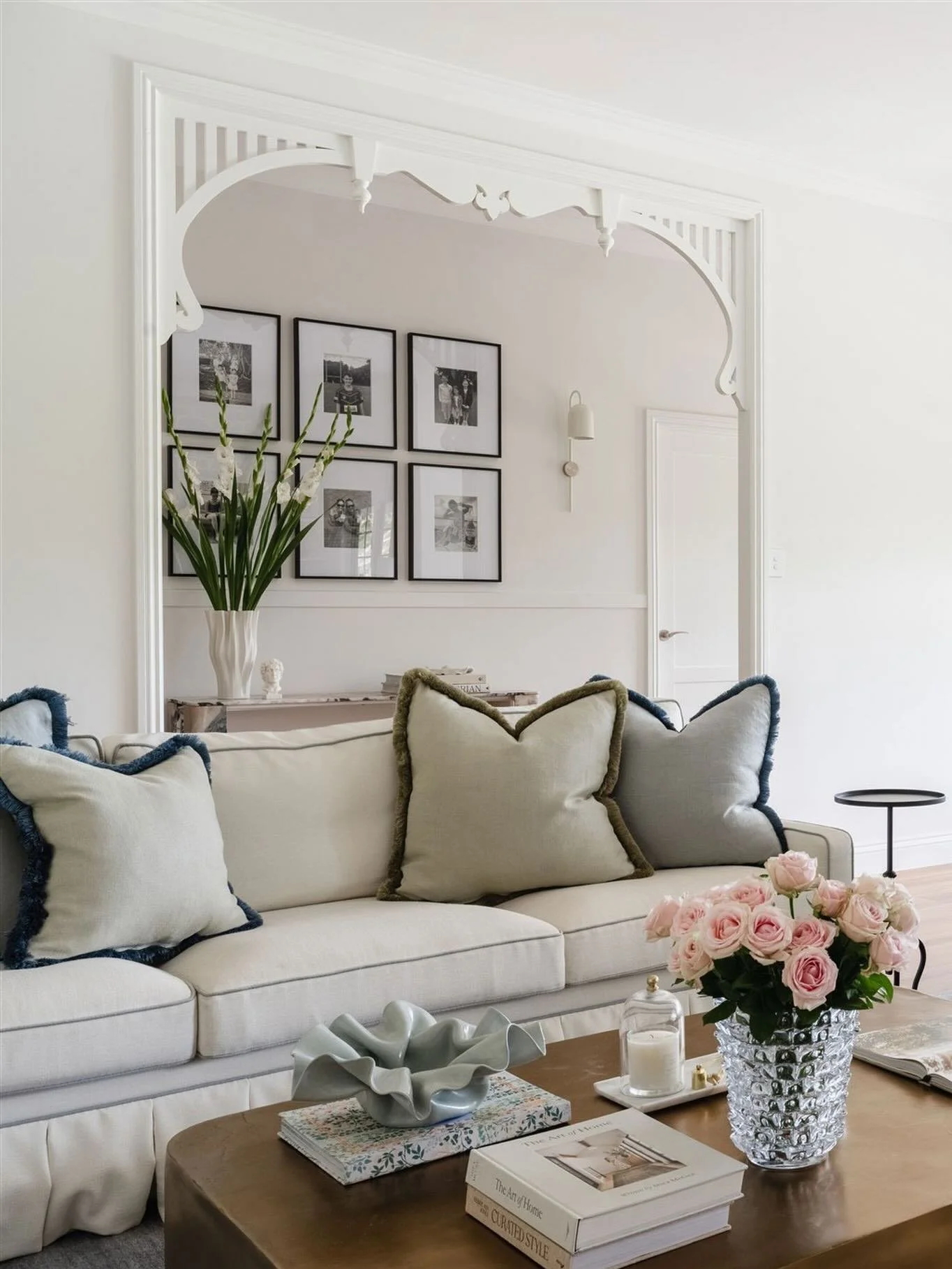 The light filled Living room at Maison de toujours feels immediately at ease. 
Custom sofas and armchairs with box pleat skirts and contrast trim are layered with brush fringed scatter cushions and a bespoke Armadillo &amp; Co rug. A brass coffee tab