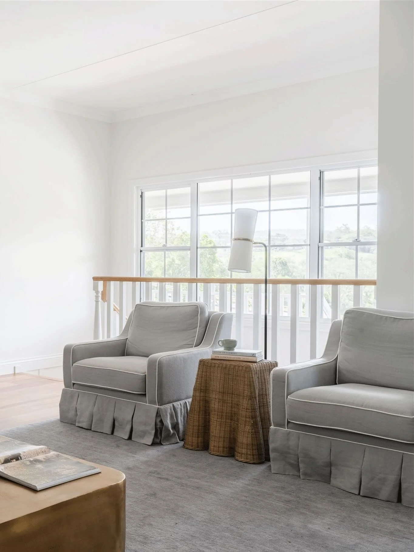 The light filled living room at Maison de toujours feels immediately at ease. 
Custom sofas and armchairs with box pleat skirts and contrast trim are layered with brush fringed scatter cushions and a bespoke @armadilloandco rug. A brass coffee table 