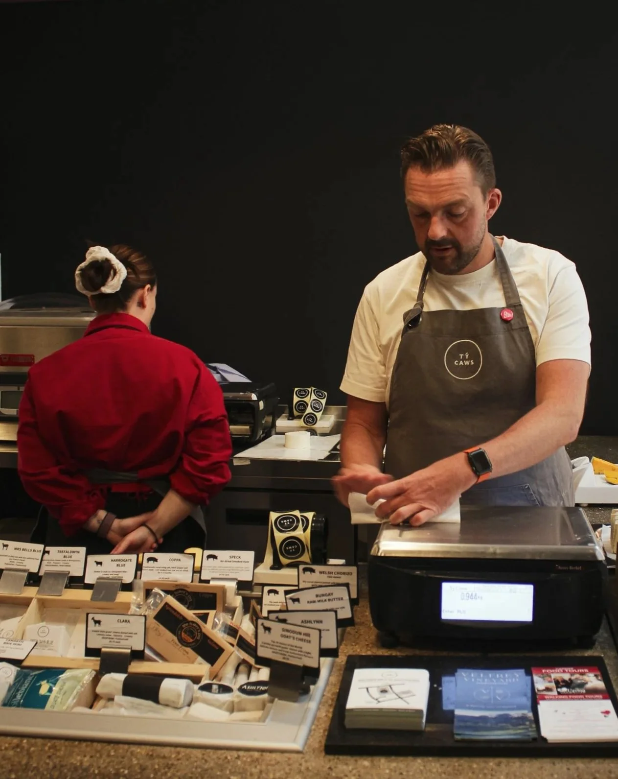 Owen preparing cheese in a Cheese & Wine Bar in Castle Arcade Cardiff.
