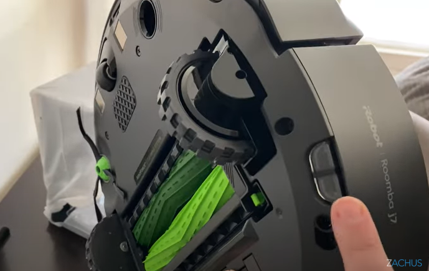 still from review video showing the side of the robot and a finger pointing to a sensor on the bottom