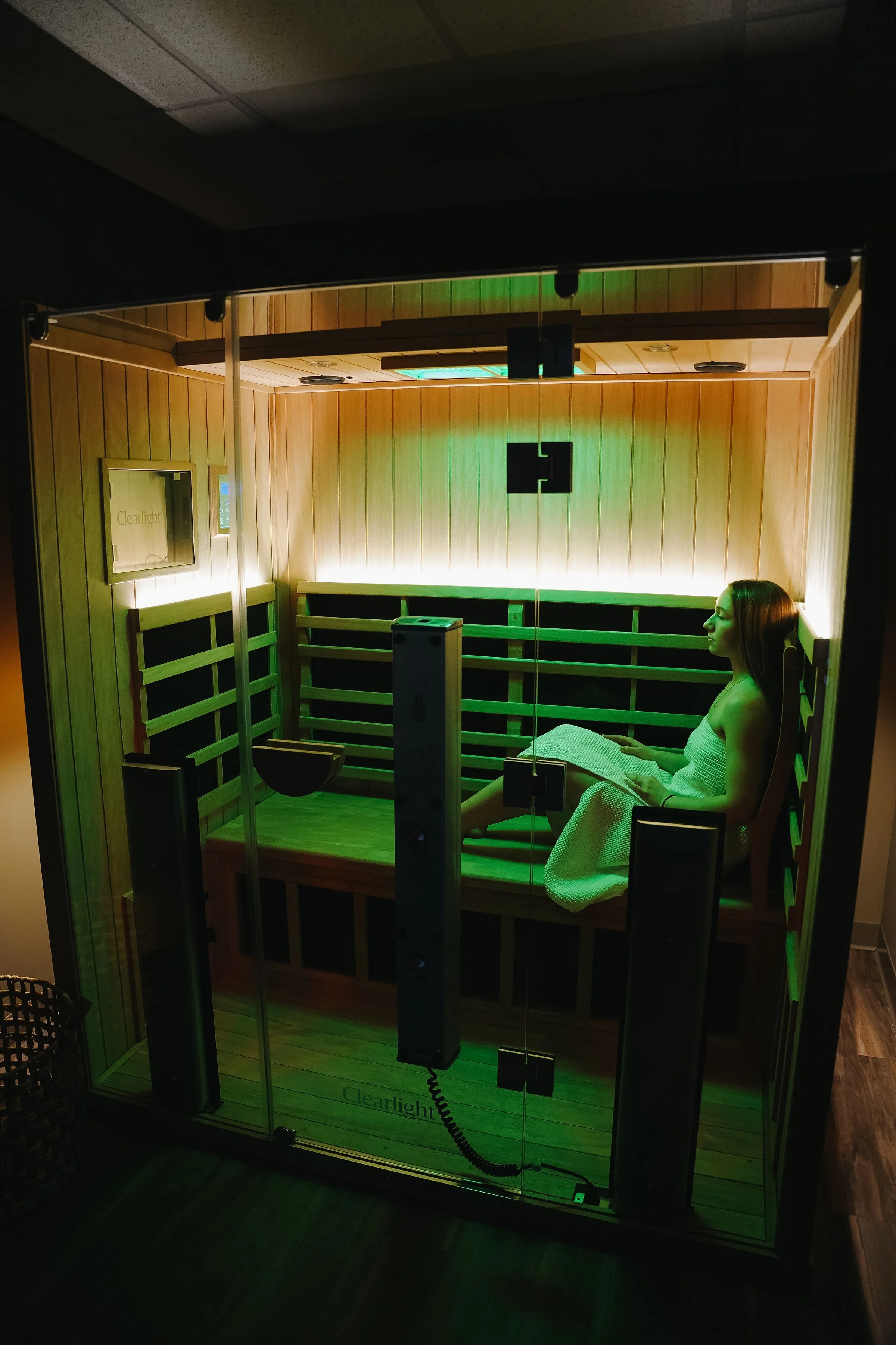 Woman inside sauna at Cedar House with green lights