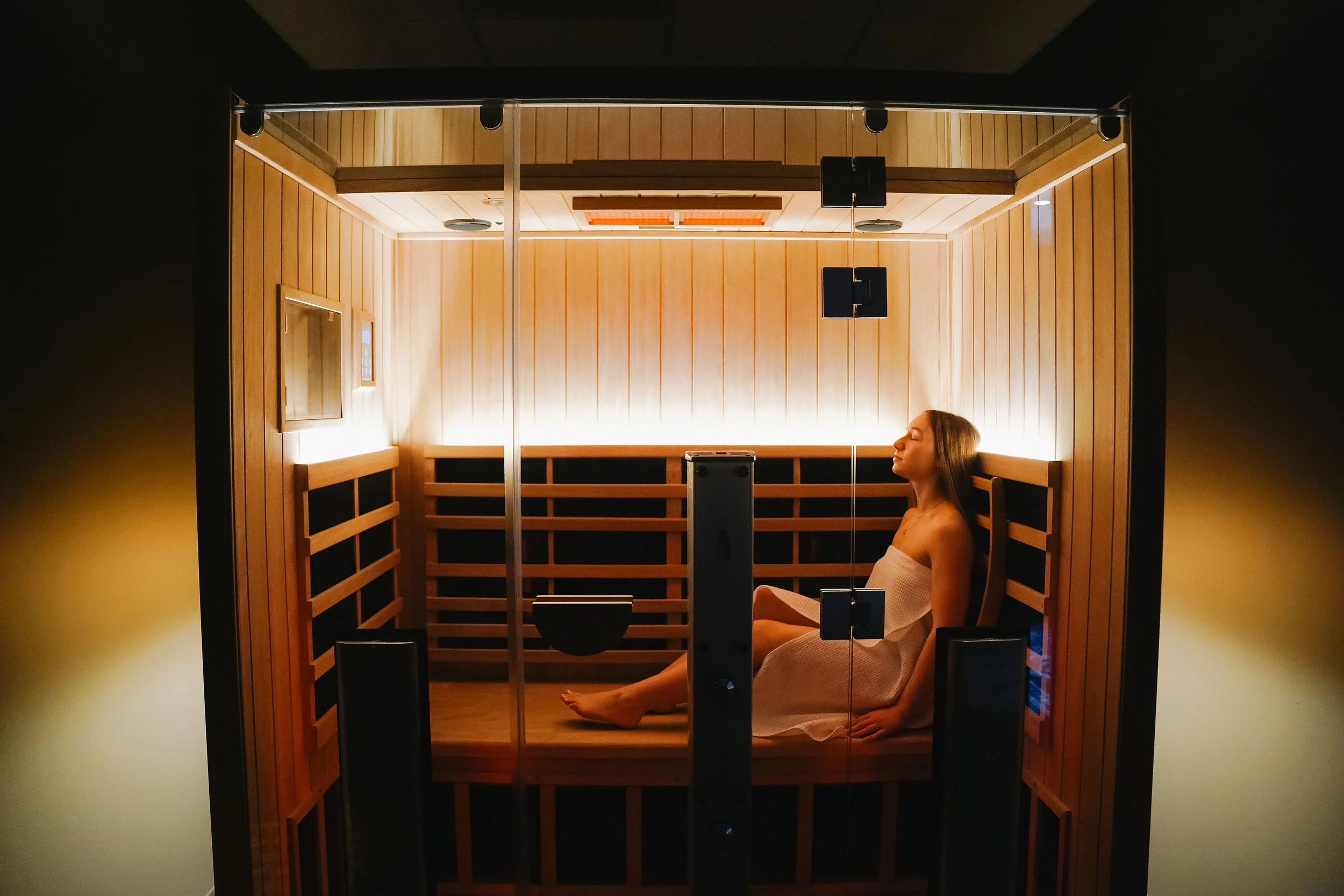 Woman inside sauna at Cedar House Wellness features warm lights.jpg