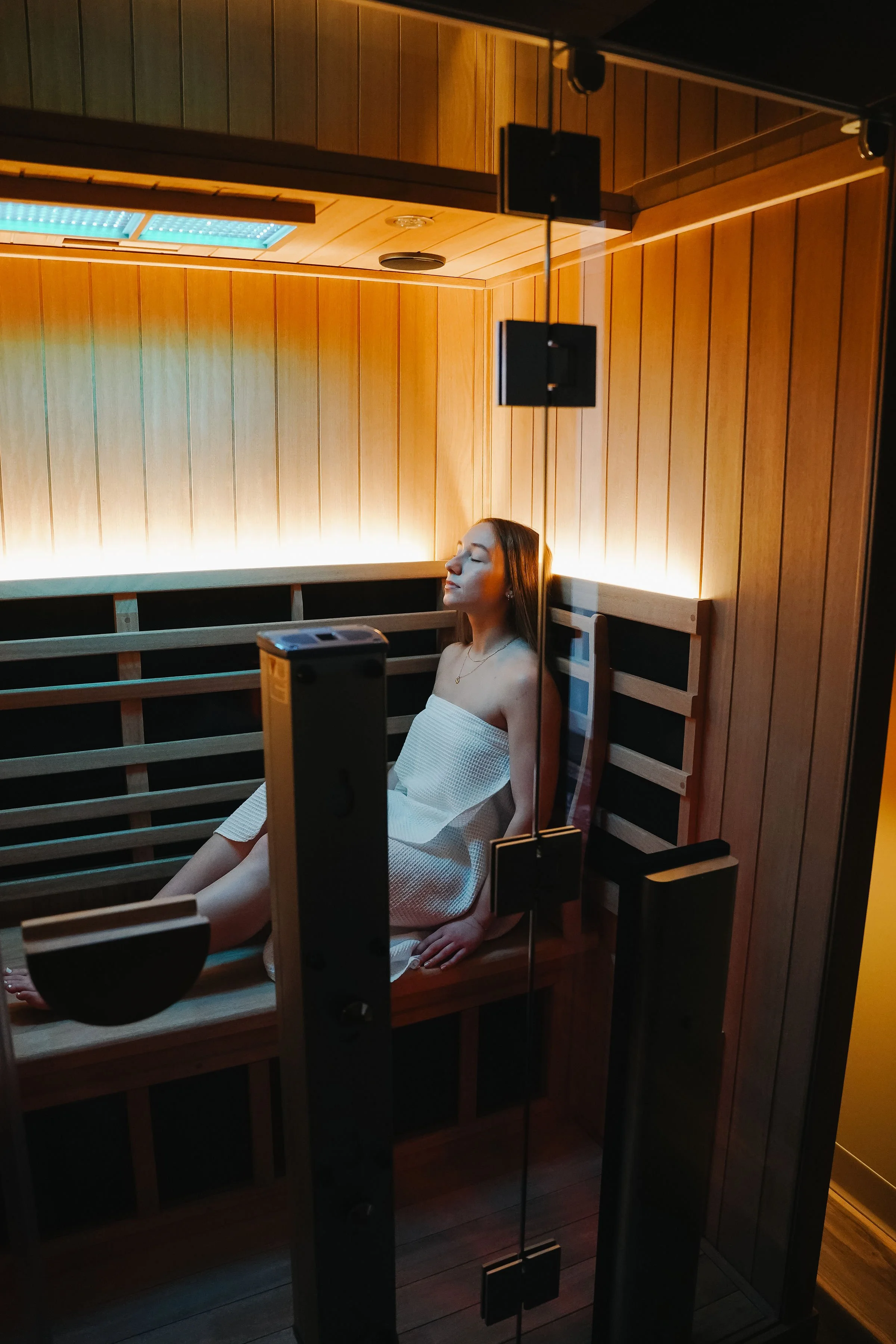 Woman relaxes inside of a sauna at Cedar House in Geneseo.jpg