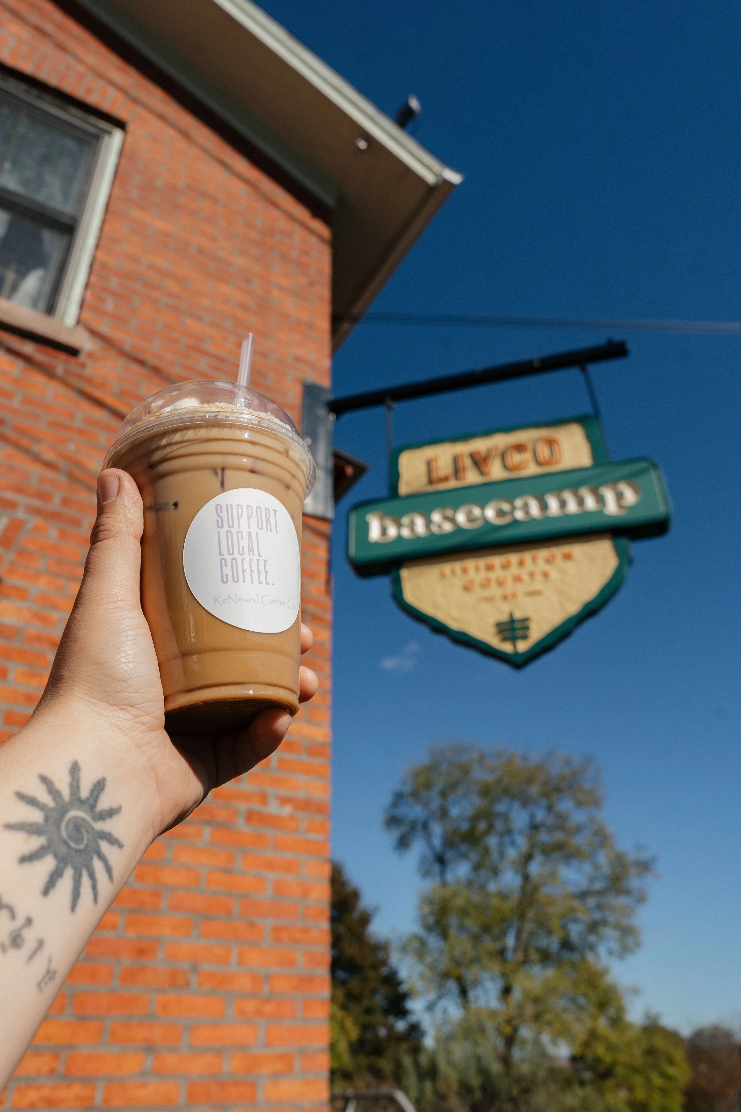 - Holding up iced coffee with whip cream at LivCo Base Camp - ReNewed Coffee Co Mount Morris.jpg